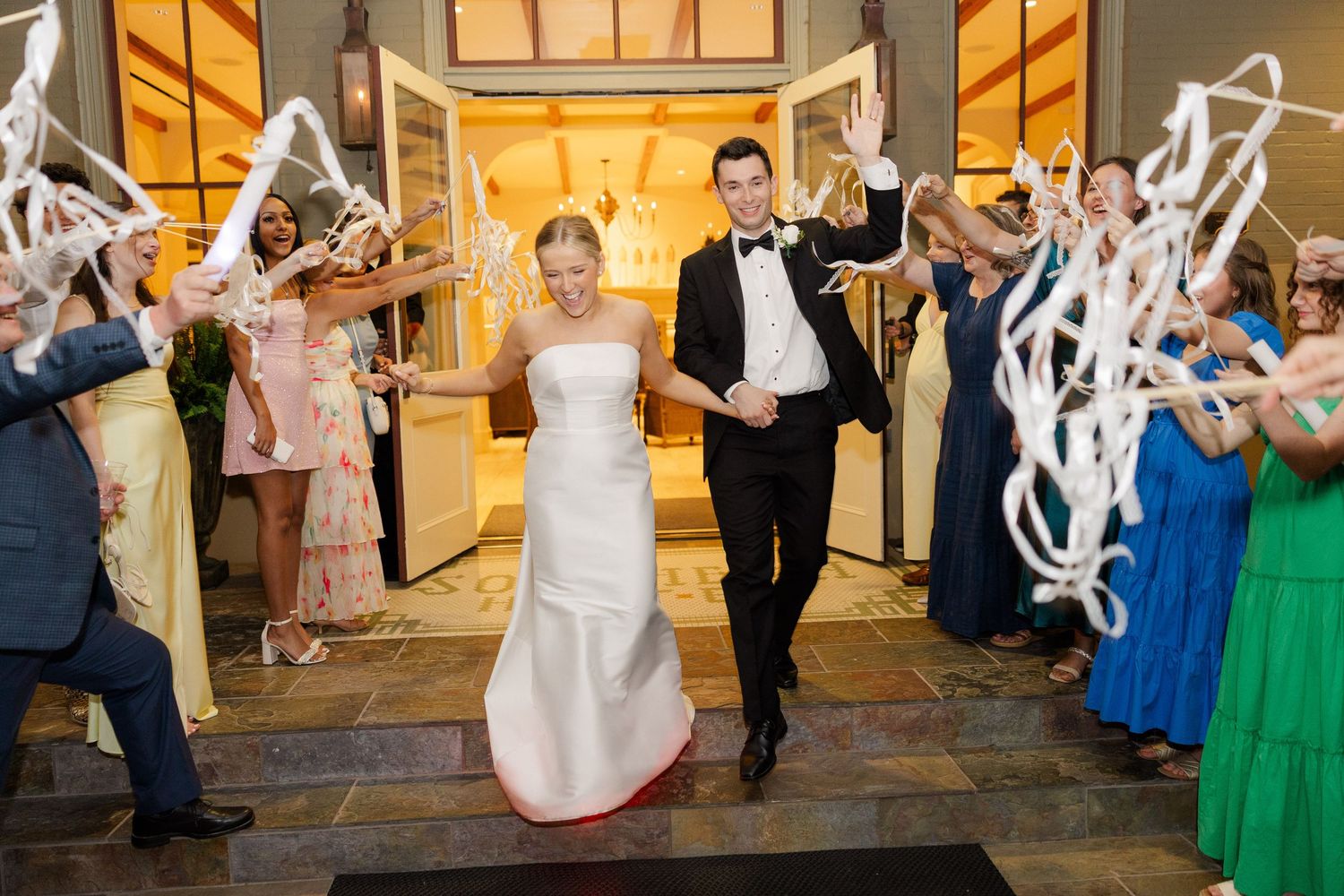 Wedding guests dance and celebrate during a lively reception in an elegantly decorated venue.