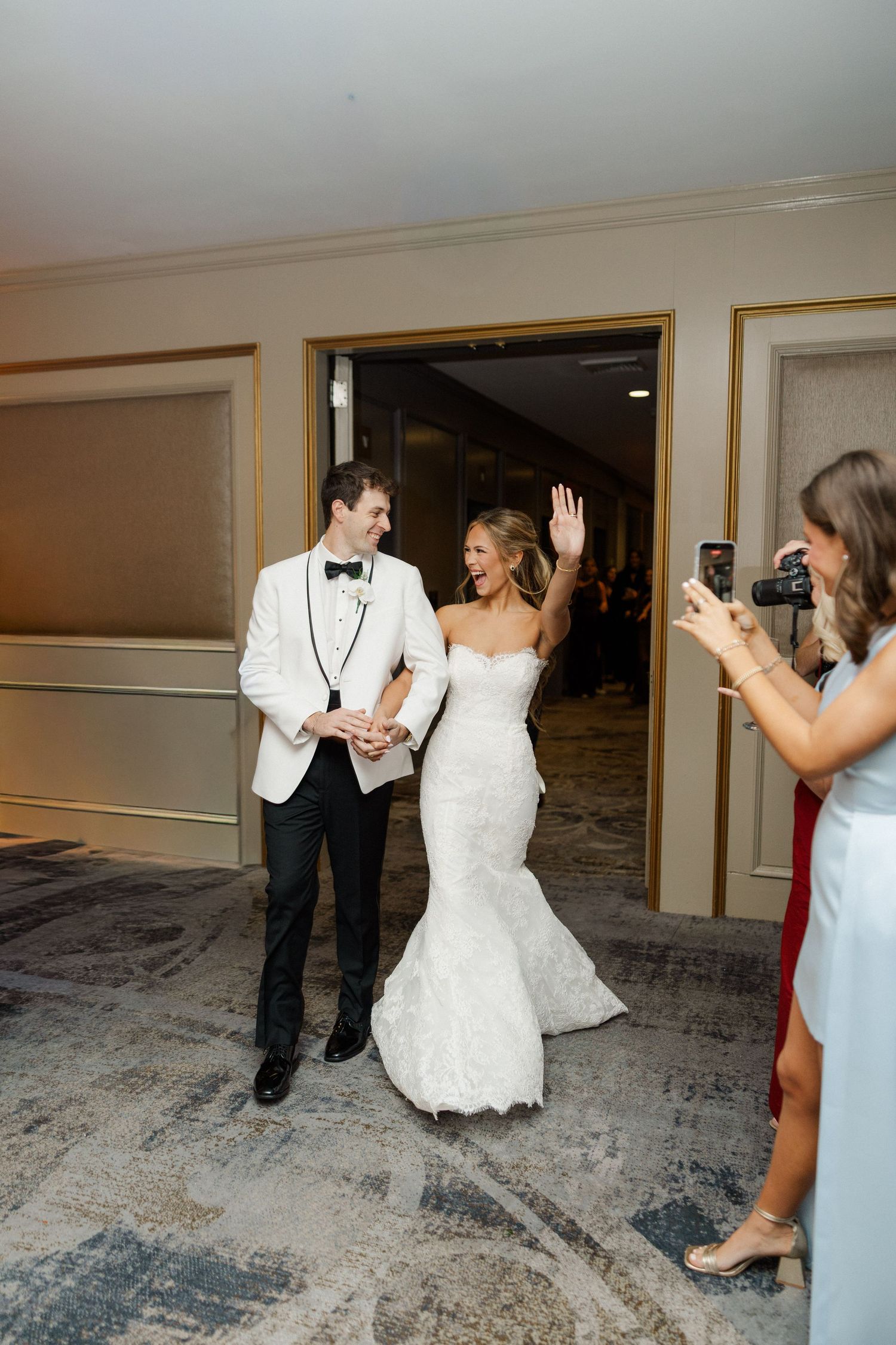 Wedding celebration in a modern venue with guests dancing and celebrating on patterned carpet.