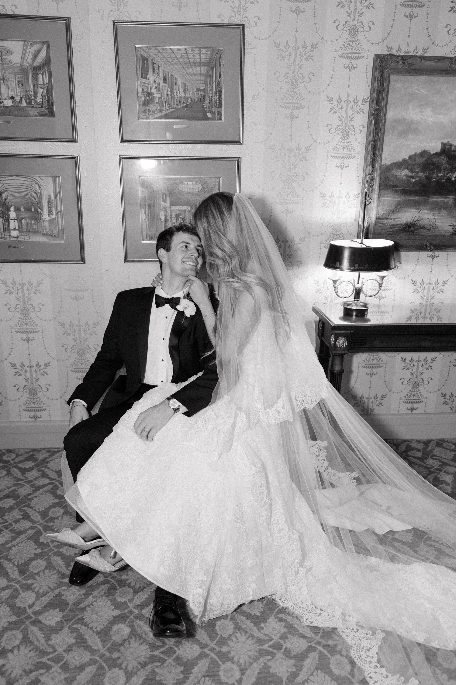 A romantic black and white wedding portrait showing a couple in formal attire.