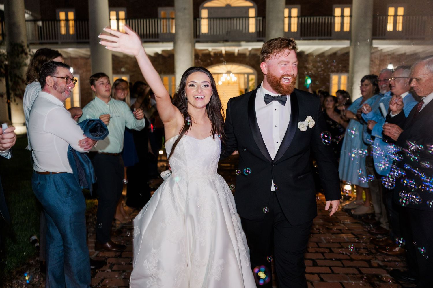 Wedding reception venue with couples dancing under warm lighting and elegant decor.