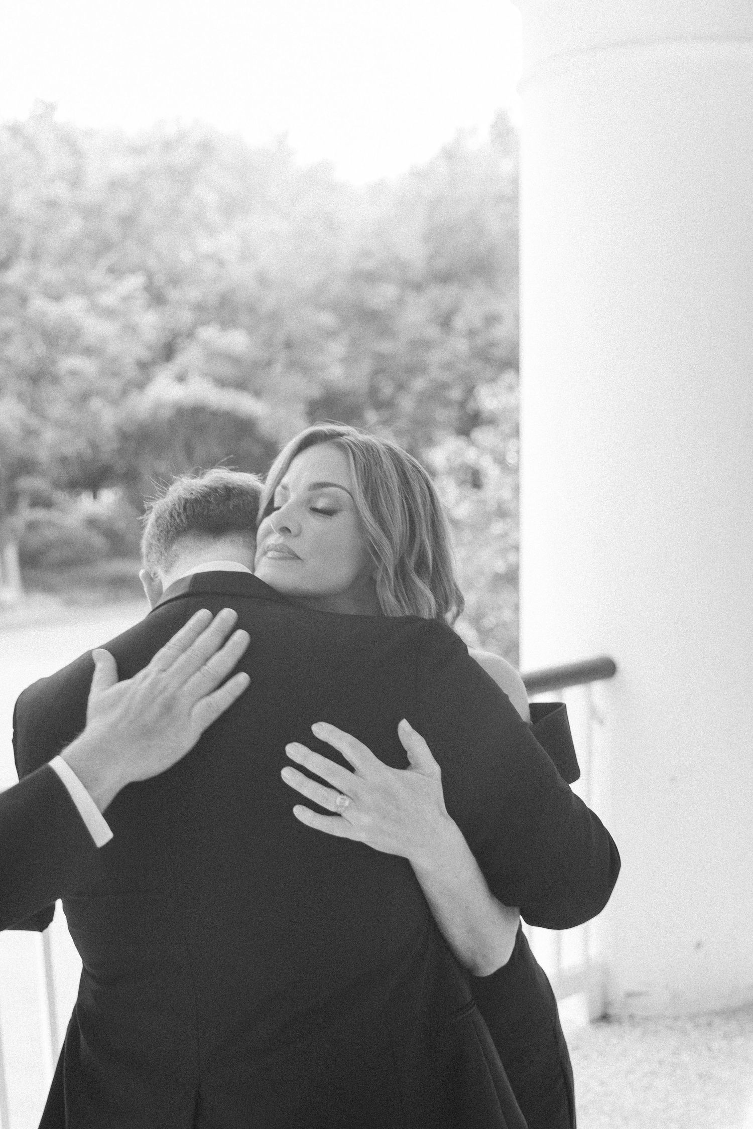 Emotional black and white photo showing intimate embrace at wedding.
