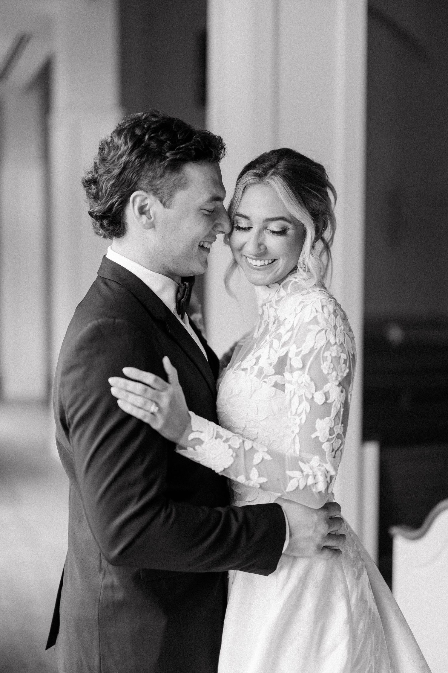 Black and white portrait of newlyweds embracing during first look photos.