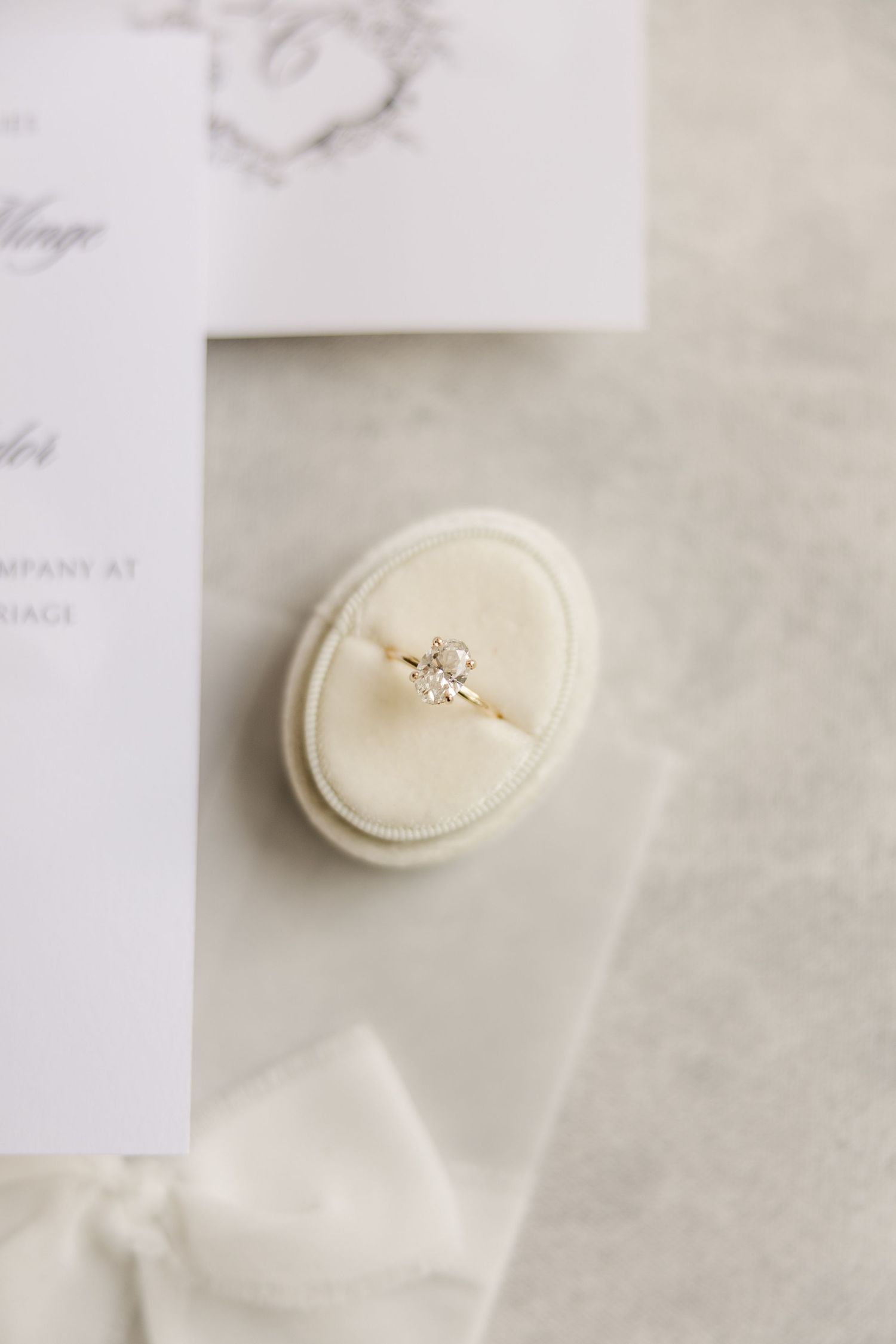 Close-up shots of a delicate engagement ring displayed on a white cushion.