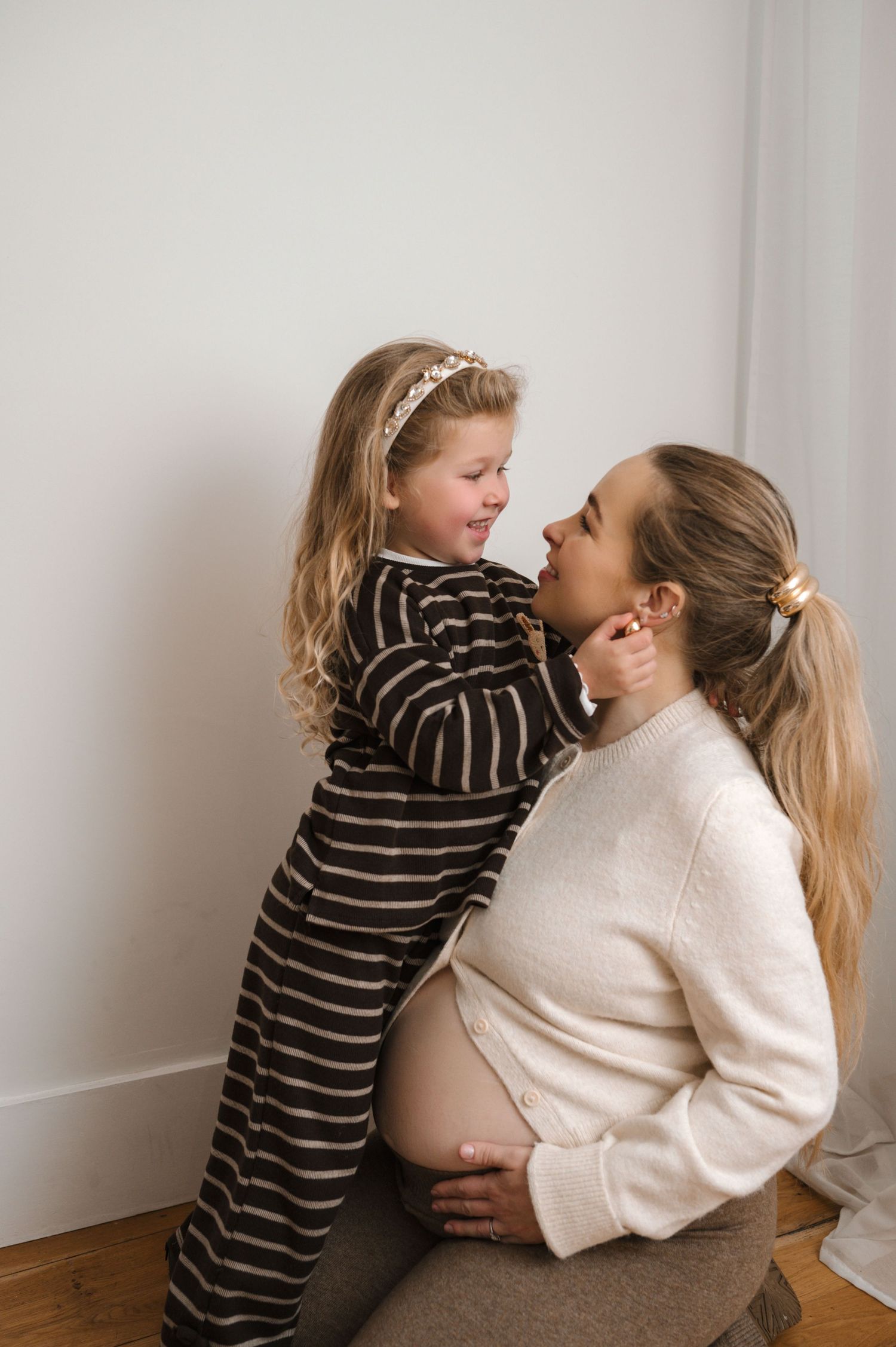 A heartwarming sequence of candid moments showing a parent and child sharing affectionate hugs against a white wall.