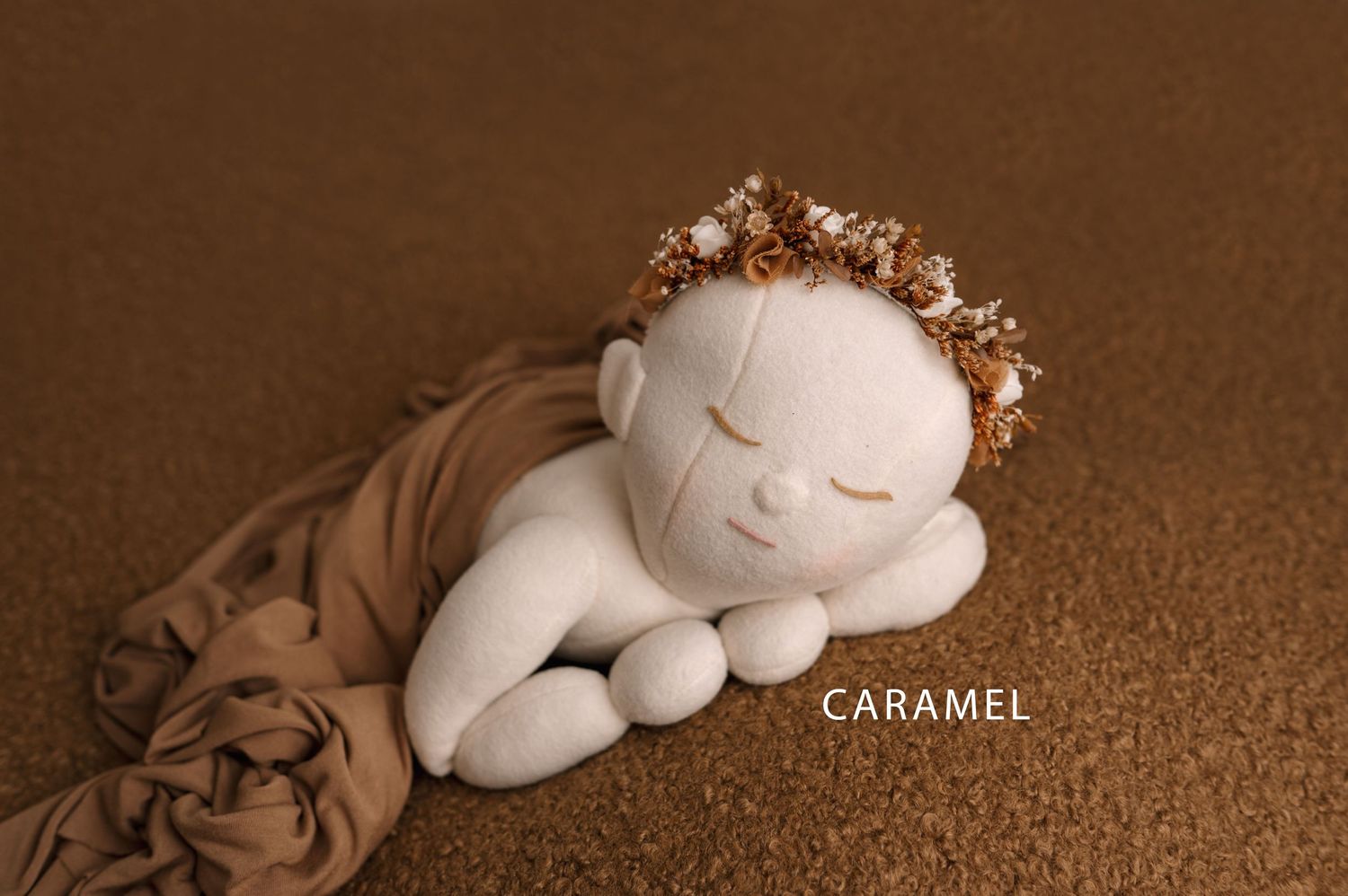 A white plush toy lamb sits against a brown textured background with the word 'caramel' visible.
