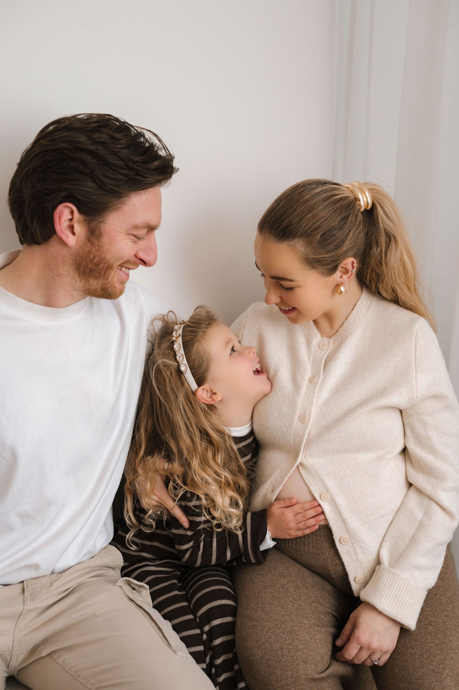 A loving family of three shares tender moments in a series of candid photos against a white background.