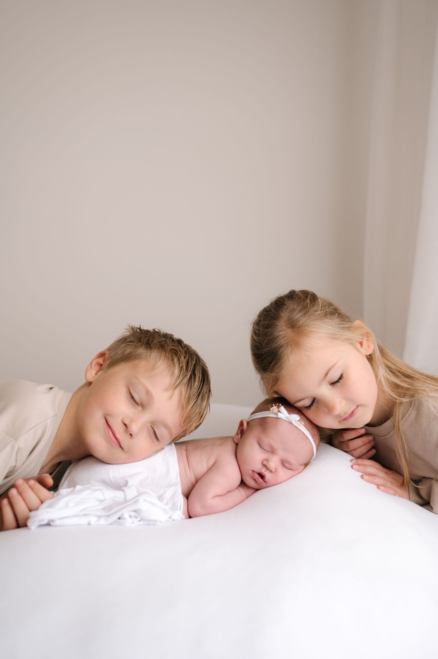 A series of connected photos showing two sleeping children laying side by side in soft, dreamy lighting.