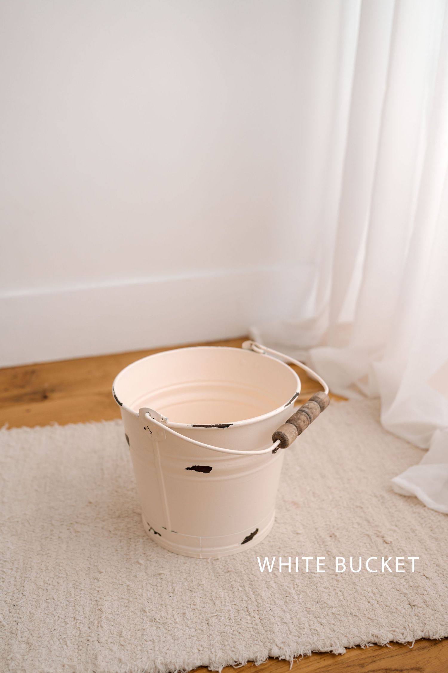 White ceramic bowl with handles sits on plush cream carpet near white curtains in natural light.