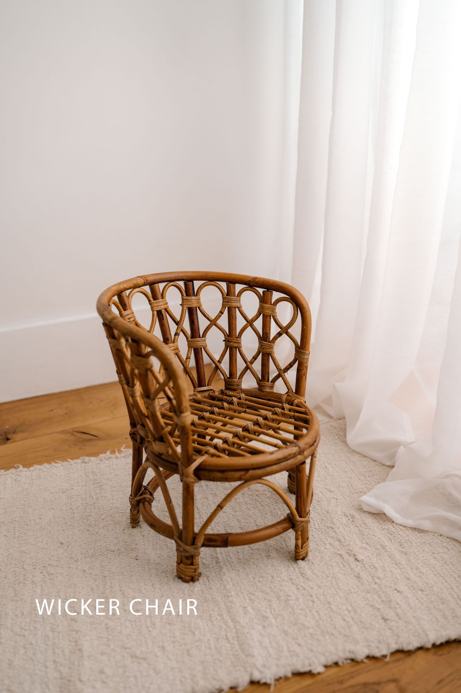 Vintage rattan wicker chair with curved design shown from multiple angles on white carpet against light curtains.
