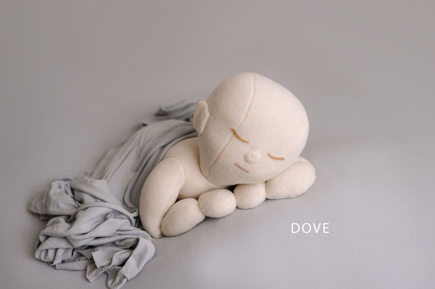 A series of minimalist photographs showing white plush toys and fabric arranged against a gray background.