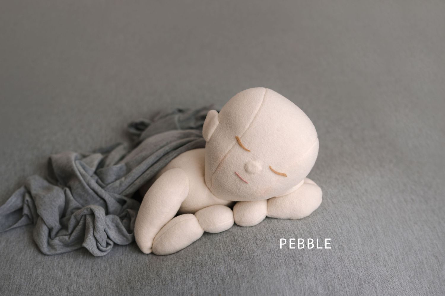 A series of clay or ceramic sculptures showing the progressive stages of a sleeping creature curled up into a ball.