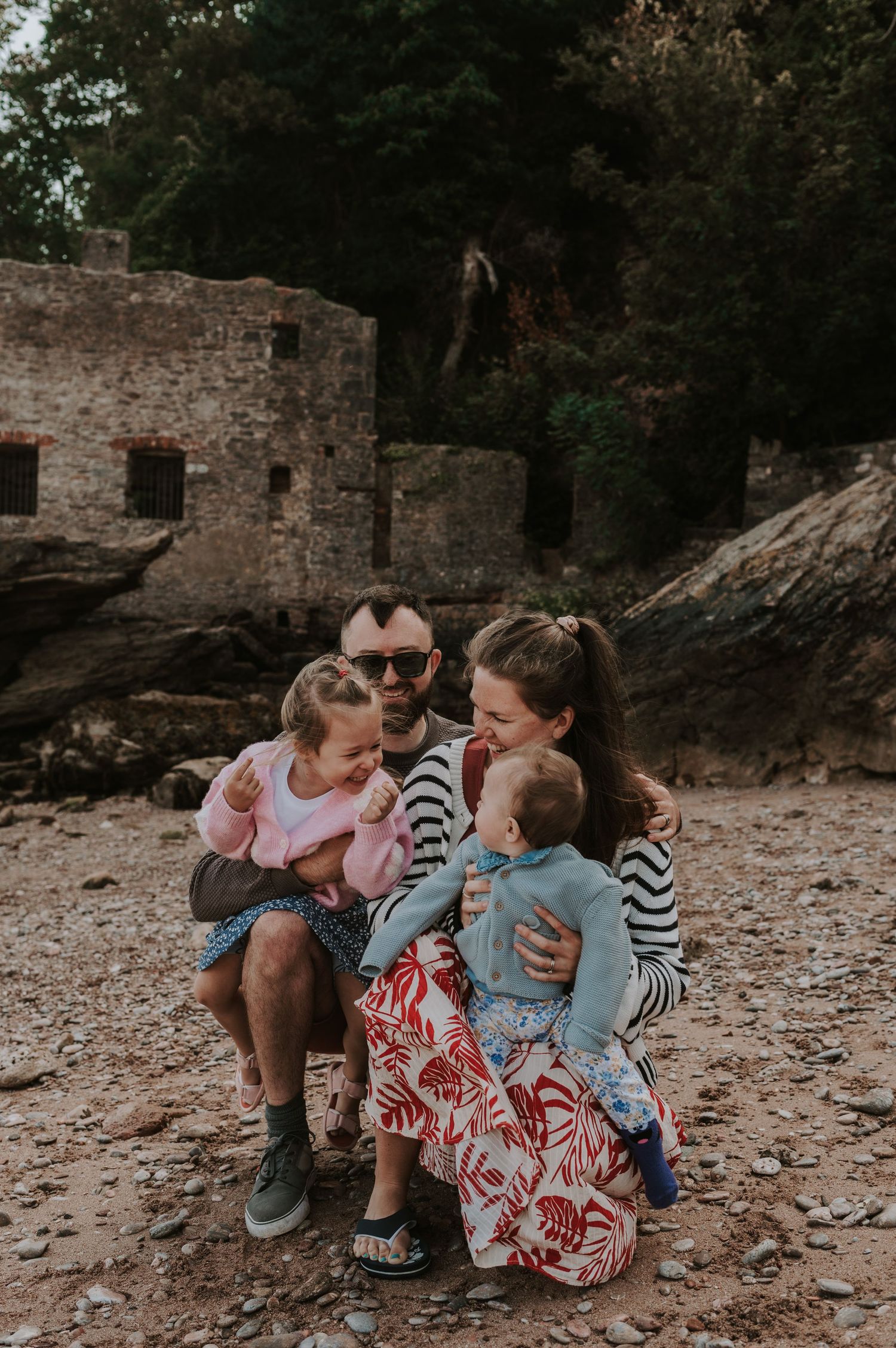 Family of four with two young children posing for a family photoshoot at Elberry Cove, Devon