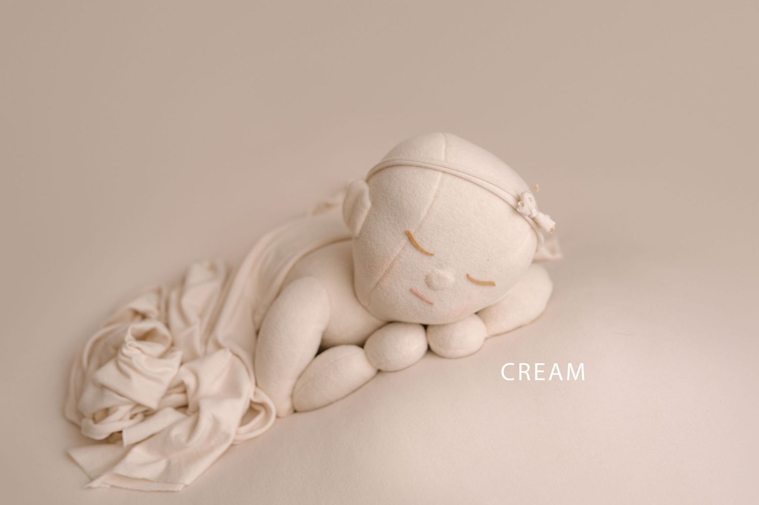 A collection of plush cloud-shaped pillows in cream color arranged in a minimalist composition.