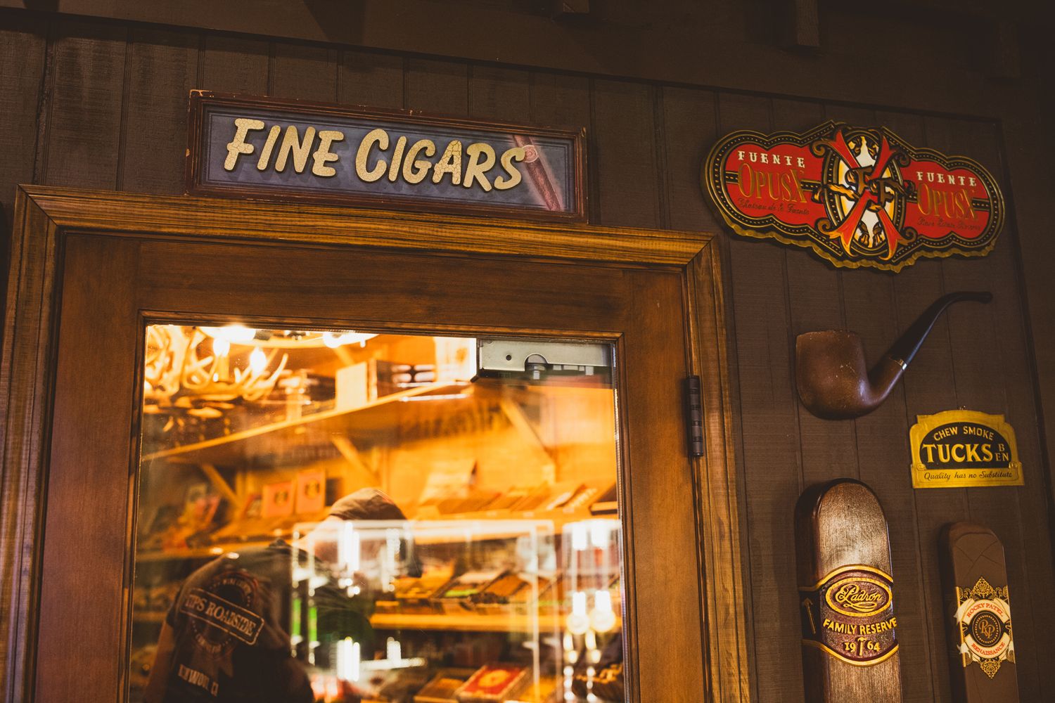 Vintage wooden framed cigar shop sign and decorative window display.