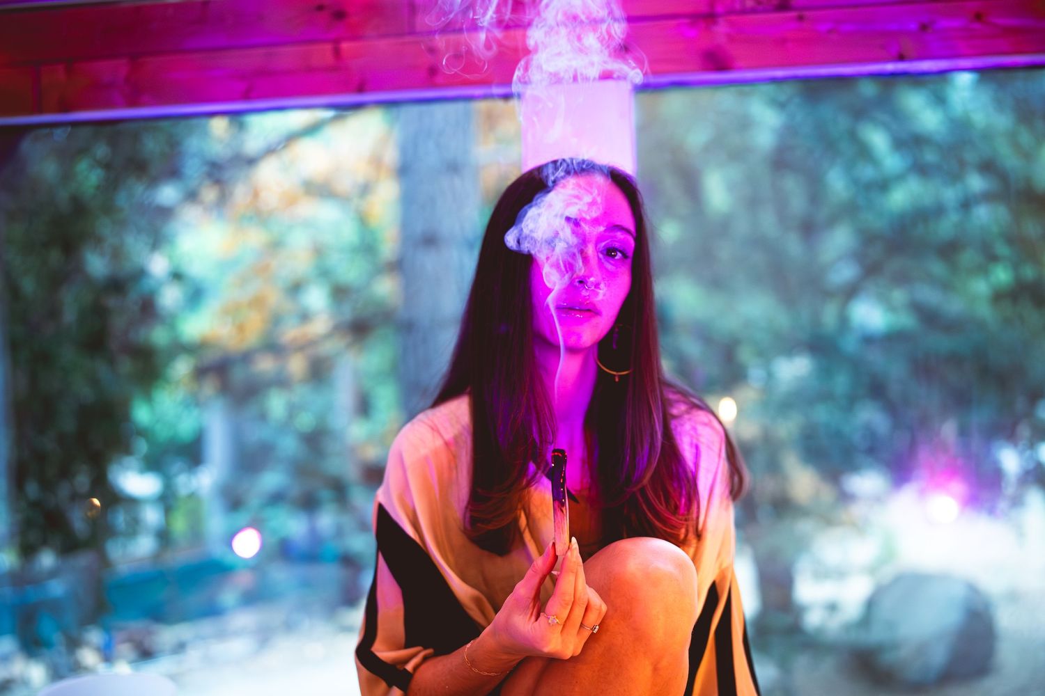 Portrait illuminated by vibrant pink neon lighting creating atmospheric effect.