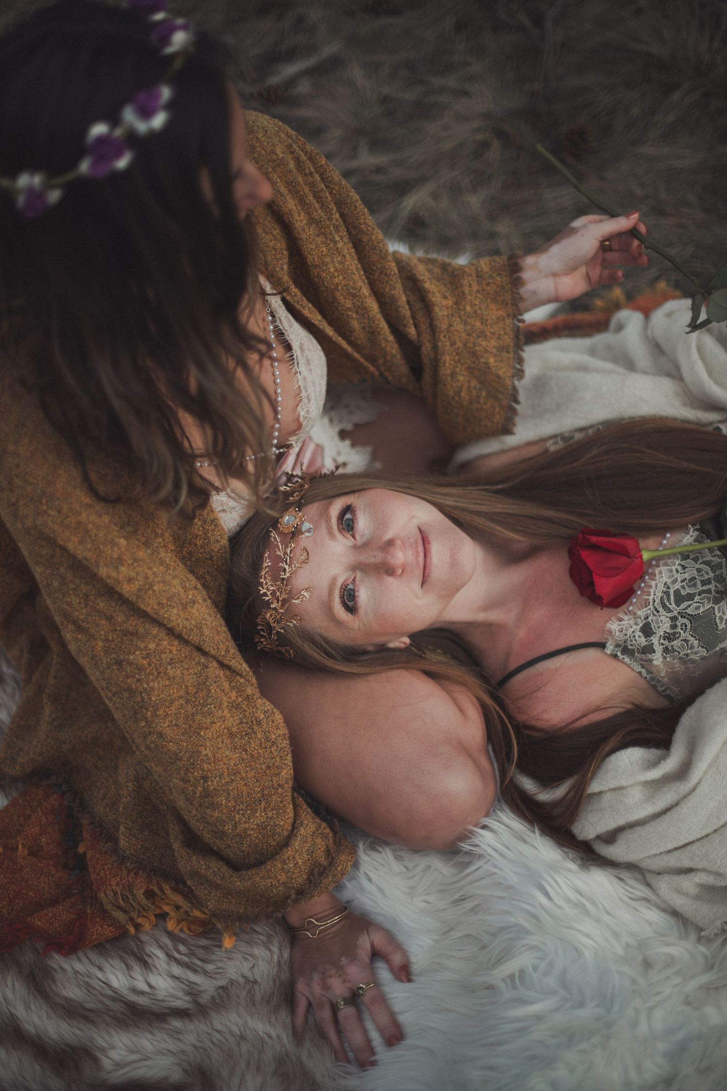 A person in a brown coat lying on a white fur blanket with floral accents and delicate decorative details.