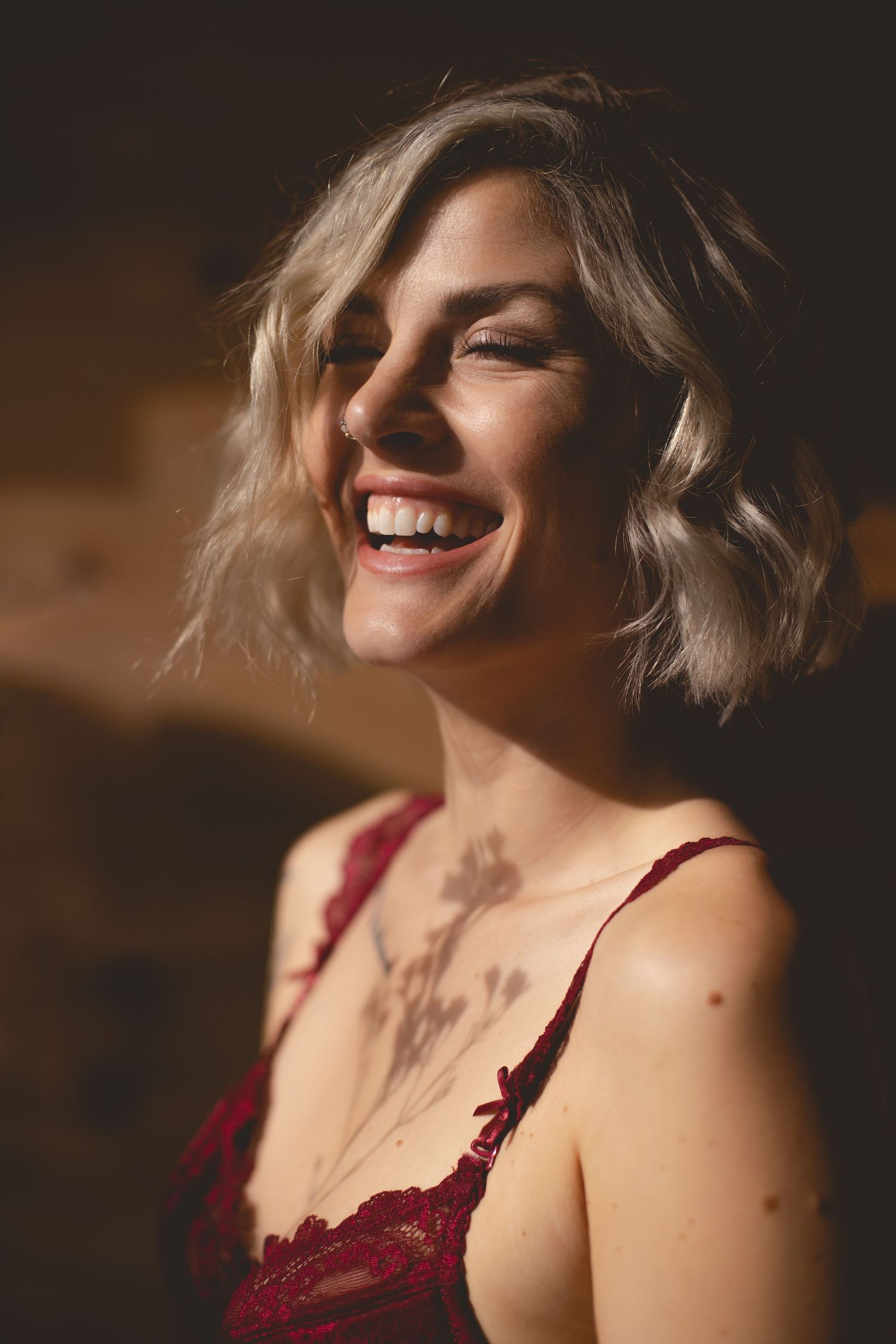 Natural light portrait capturing joyful expression and wavy blonde hair.