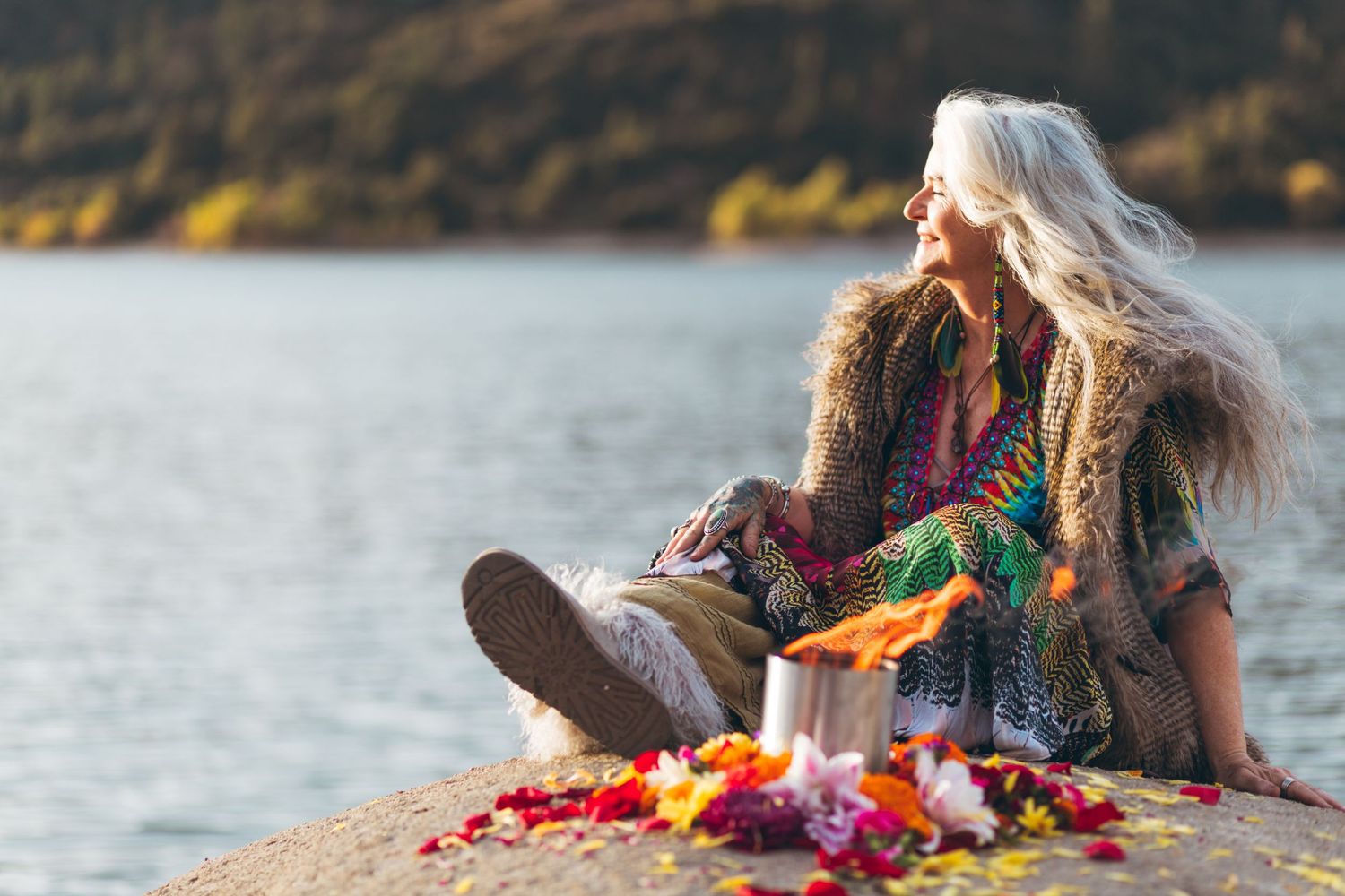 Peaceful lakeside moment with colorful autumn decor and cozy bohemian styling.