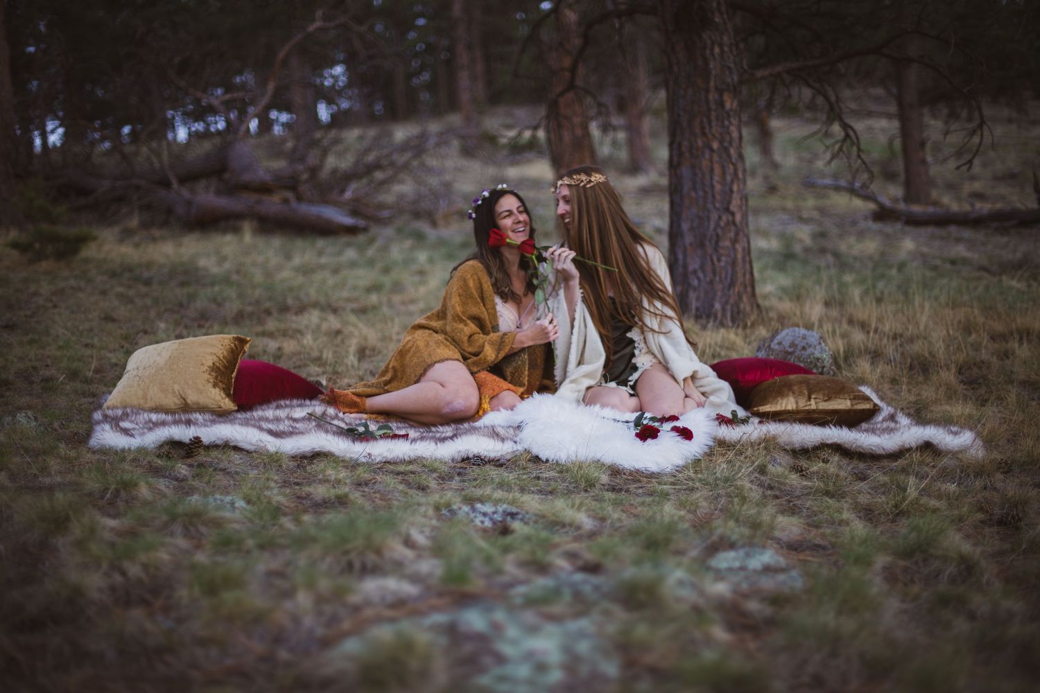 Two friends share a cozy blanket picnic in a peaceful woodland setting on a warm autumn day.