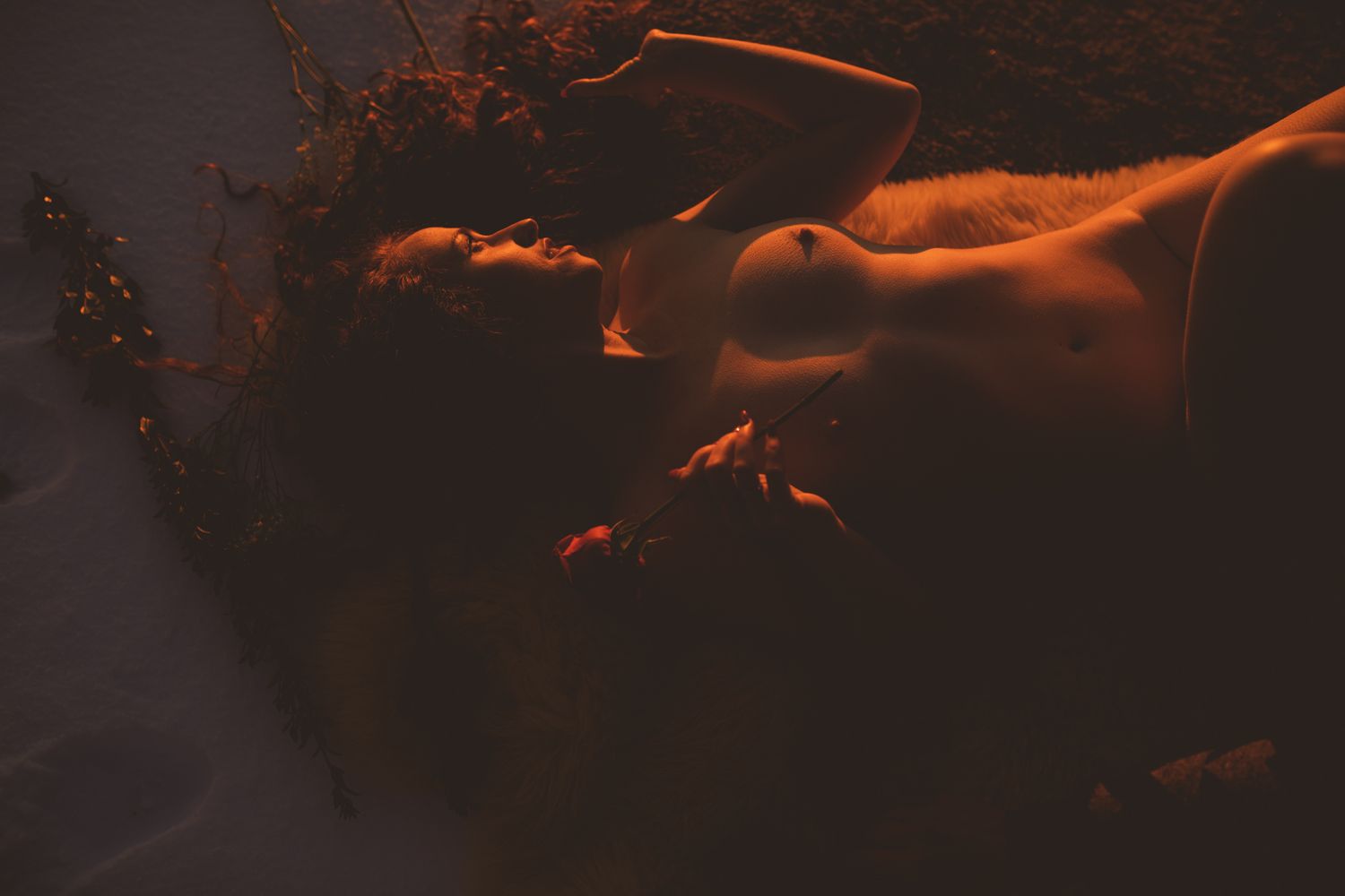 Abstract artistic nude silhouette in dark orange lighting.