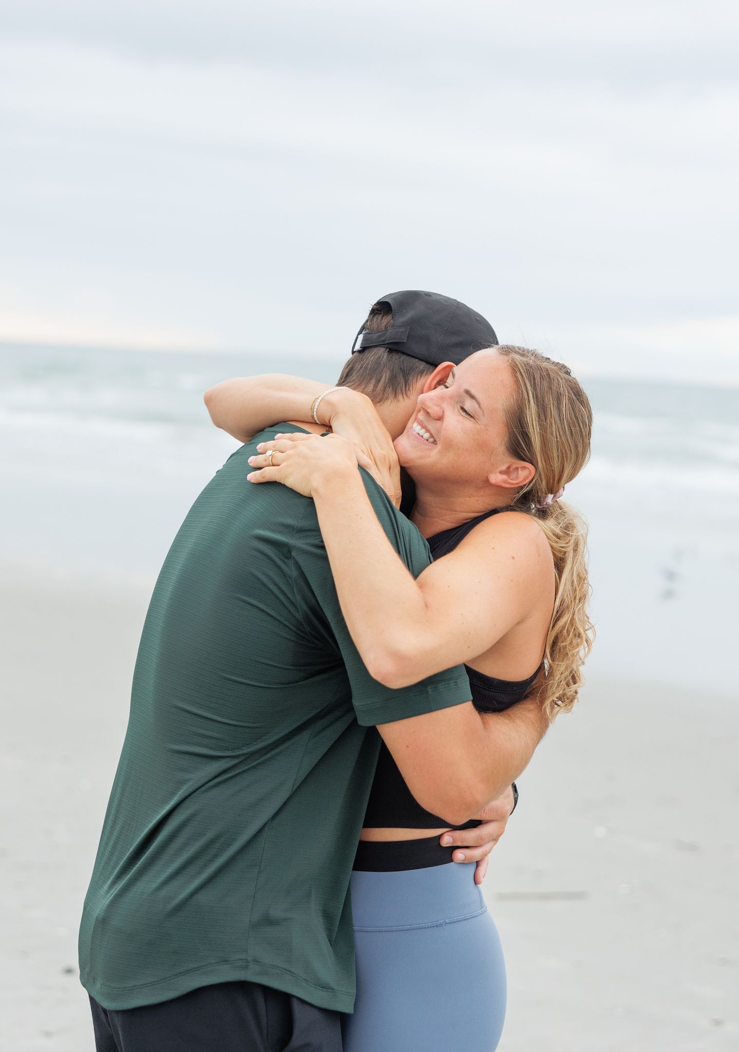 Two people share a romantic embrace on a misty beach during what appears to be an emotional moment.