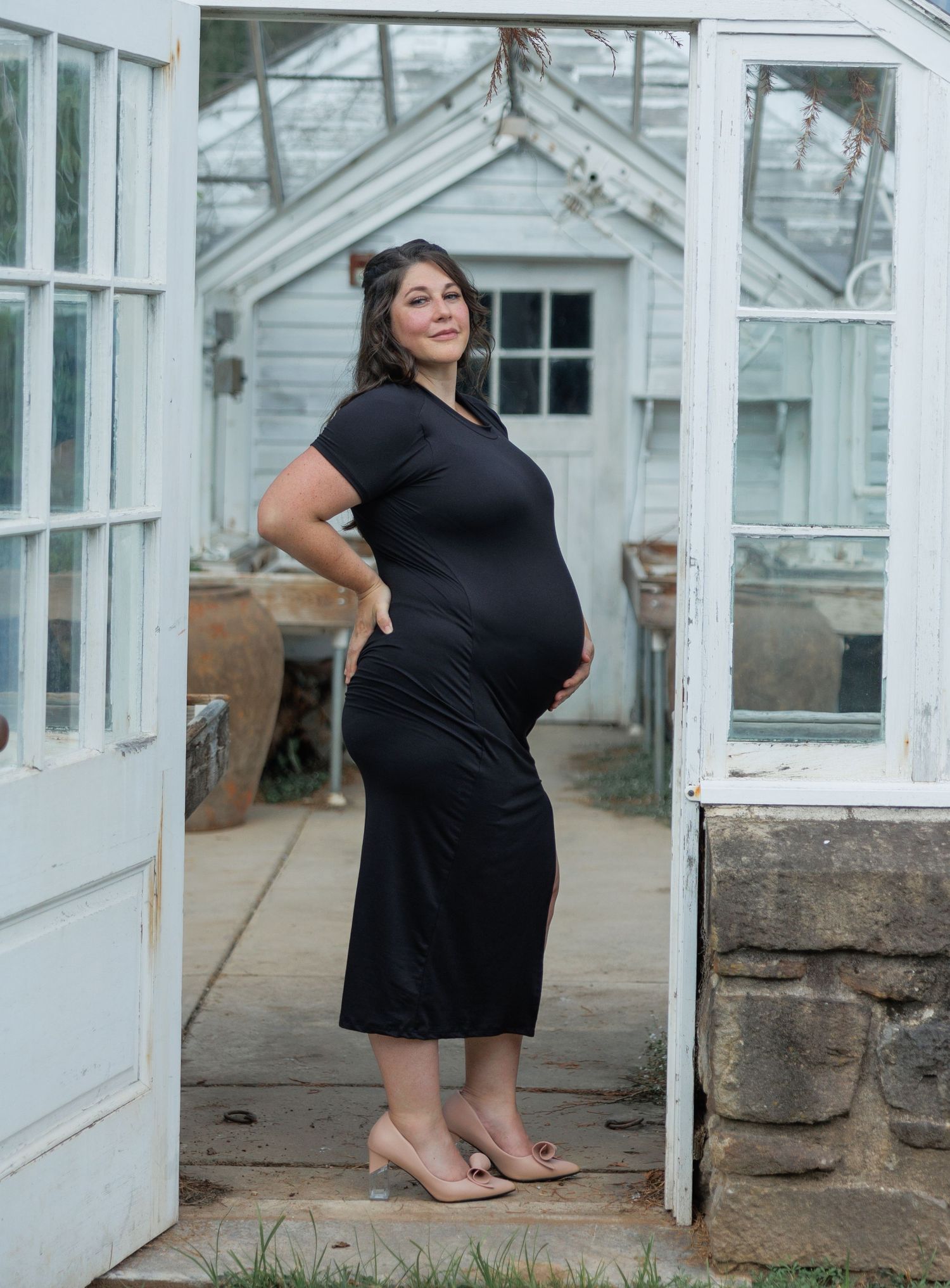 A person in a black dress poses in different angles against a white greenhouse or conservatory structure.
