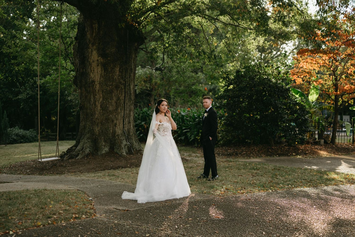 Bride and groom share a romantic moment beneath a large tree during their Church Point Manor wedding in Virginia Beach.