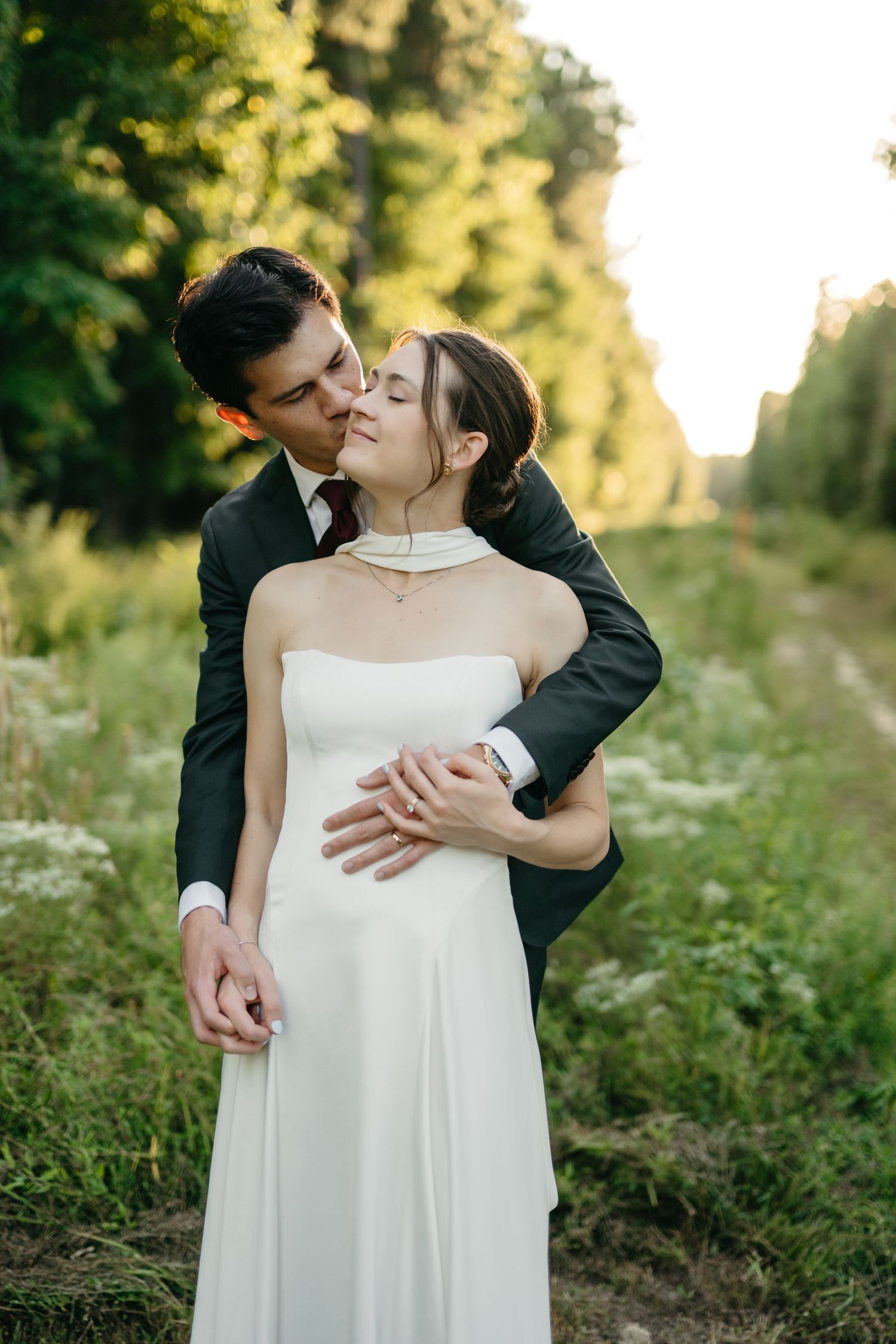 ride and groom share a romantic golden hour kiss in a meadow during their wedding at The Main at Williamsburg in Virginia.
