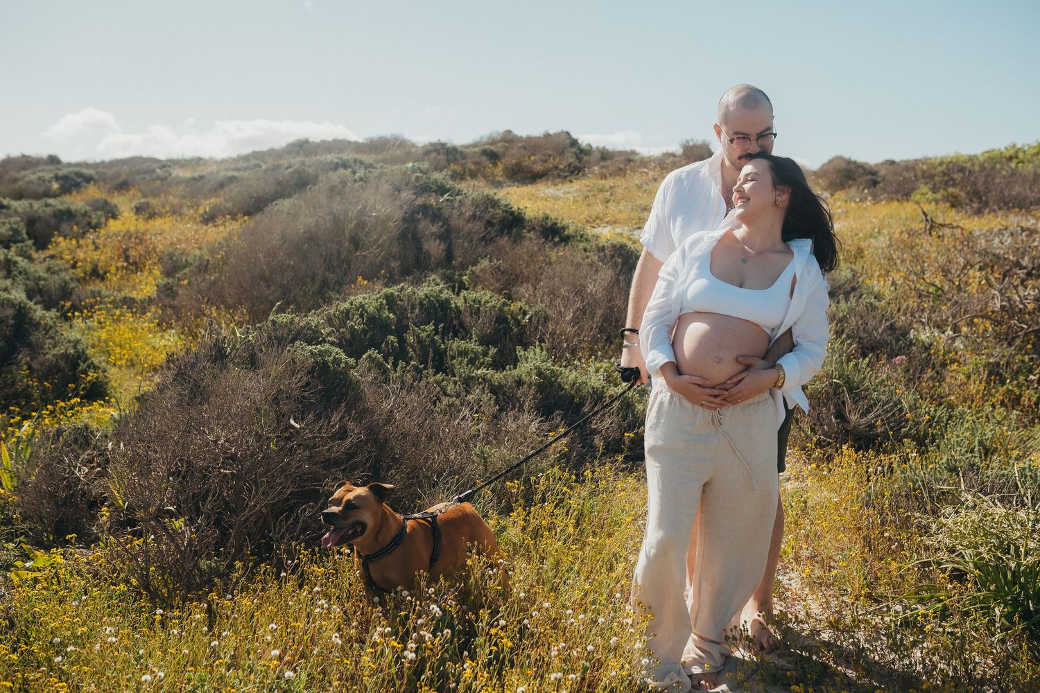 Couple and their family enjoy the beach together with their dog