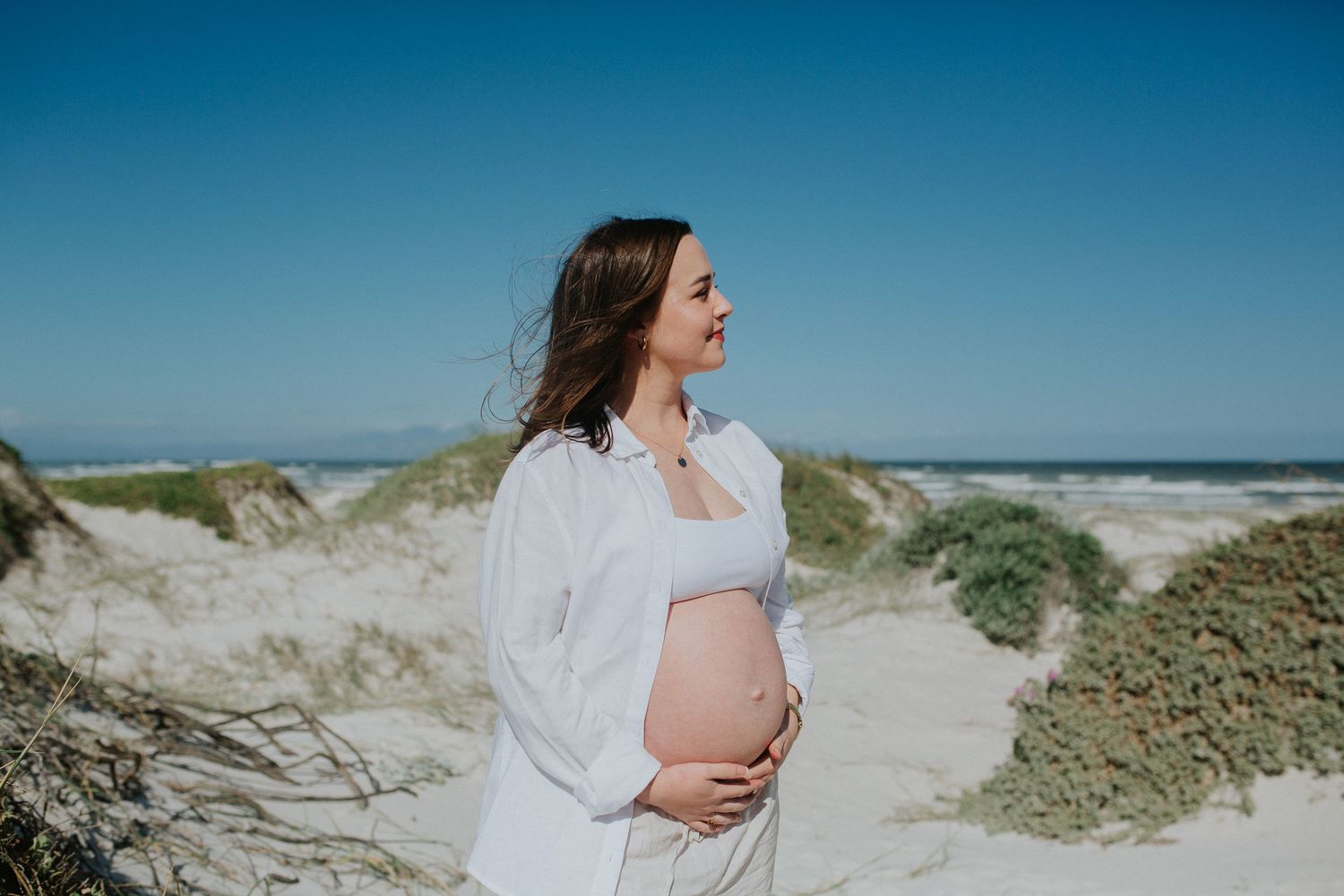pregnant woman standing on beach in maternity shoot