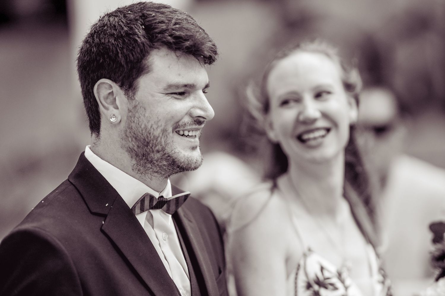 Black and white wedding photos showing moments of joy and laughter between a couple and guests during the celebration.