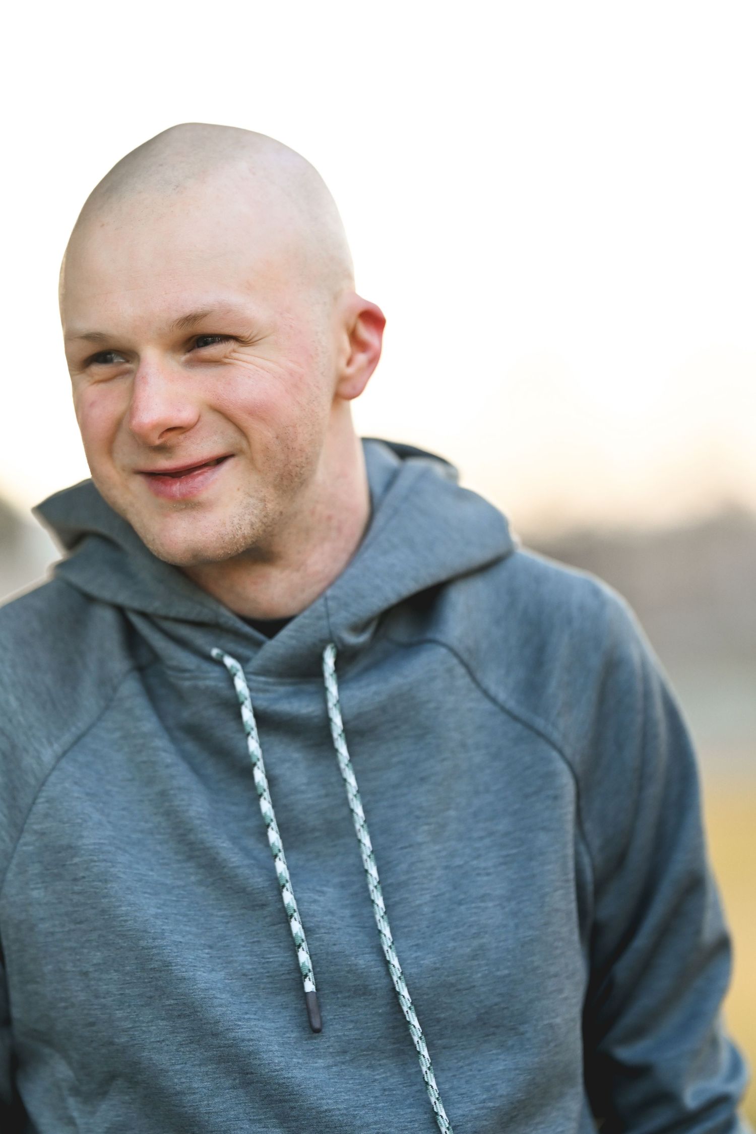 Portrait series showing changing expressions while wearing a gray hoodie and looking to the side.