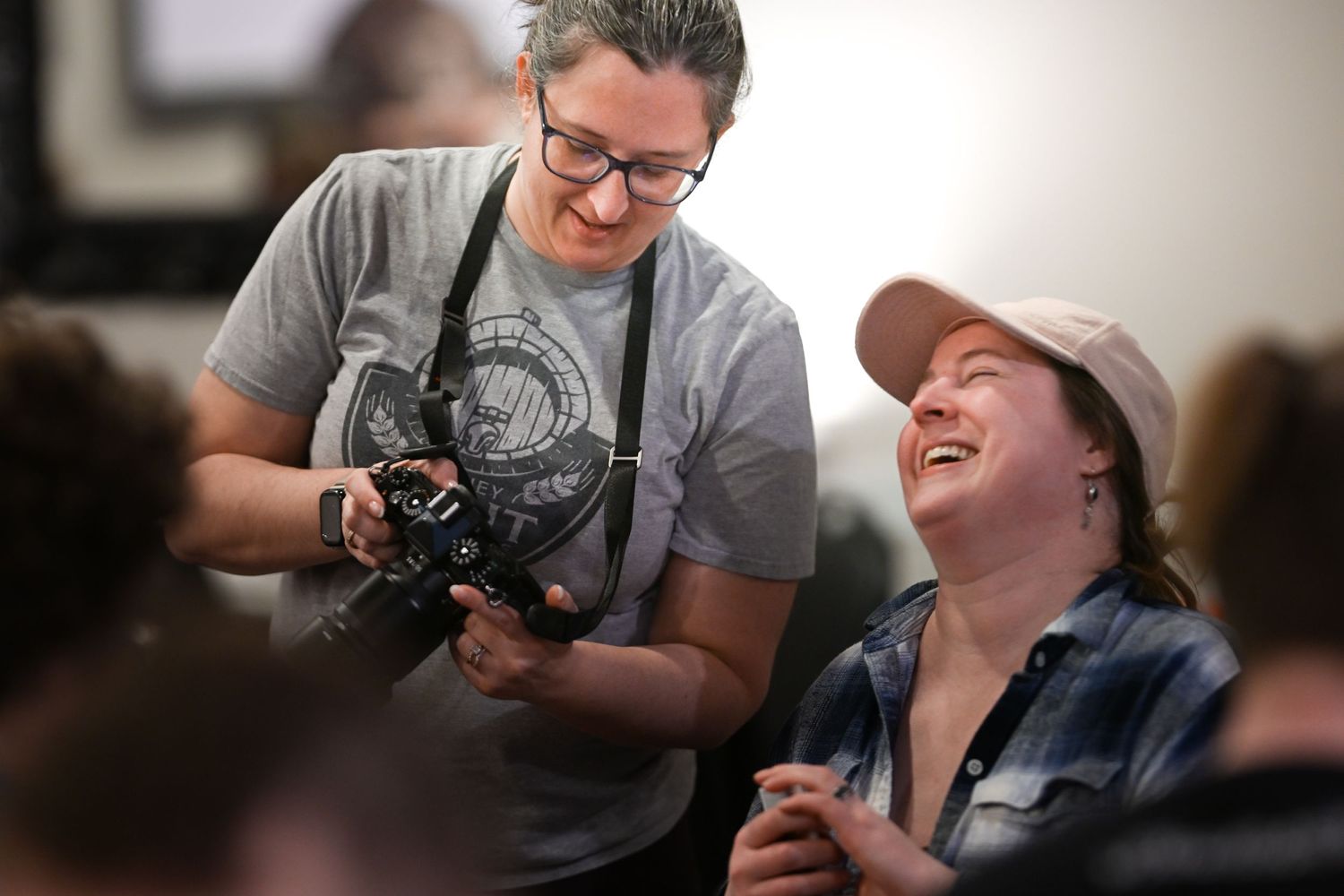 A camera operator and companion share a joyful moment while filming indoors with professional equipment.