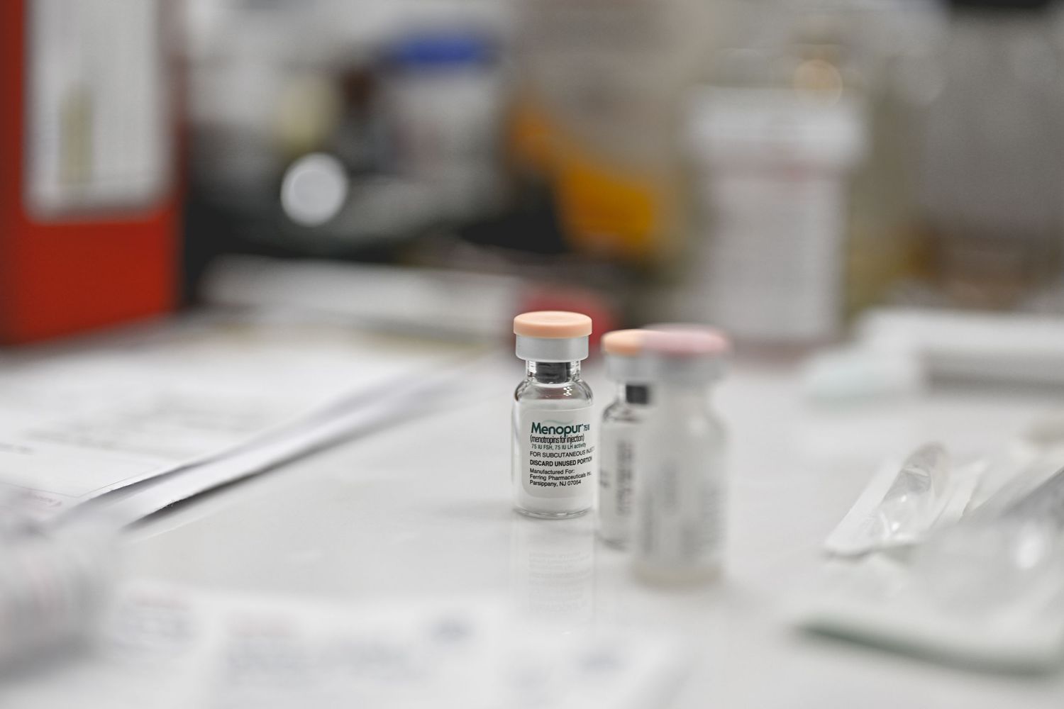 Medical vials and syringes arranged on a white surface in a laboratory setting.
