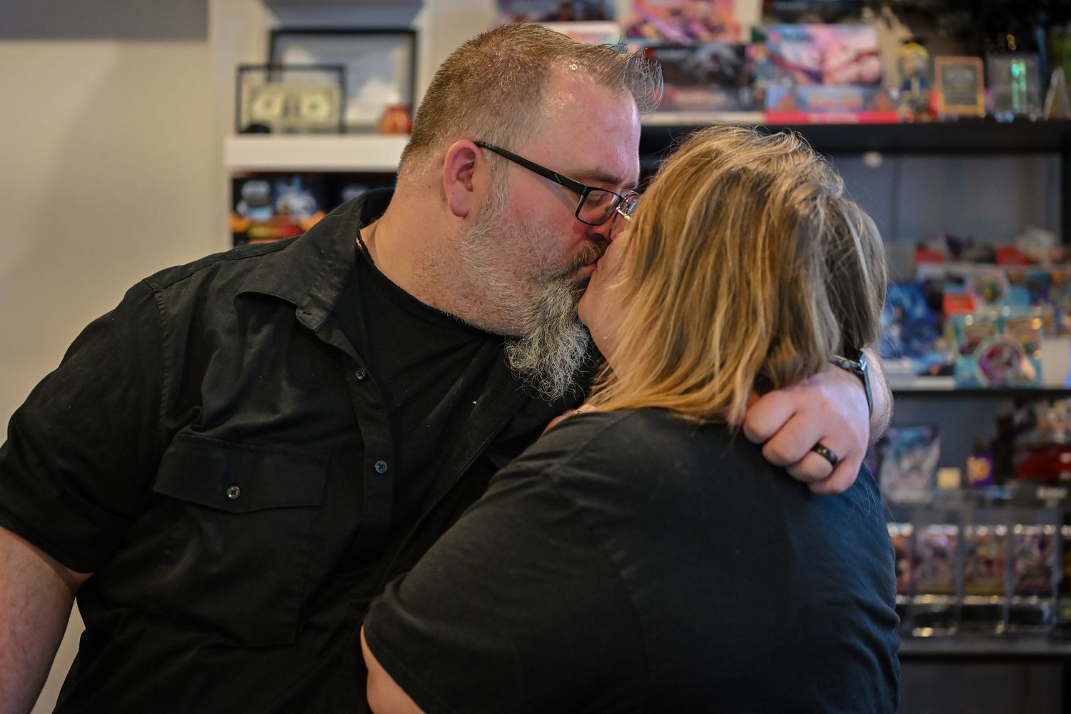 A parent and child share a tender moment together in front of store shelves filled with merchandise.