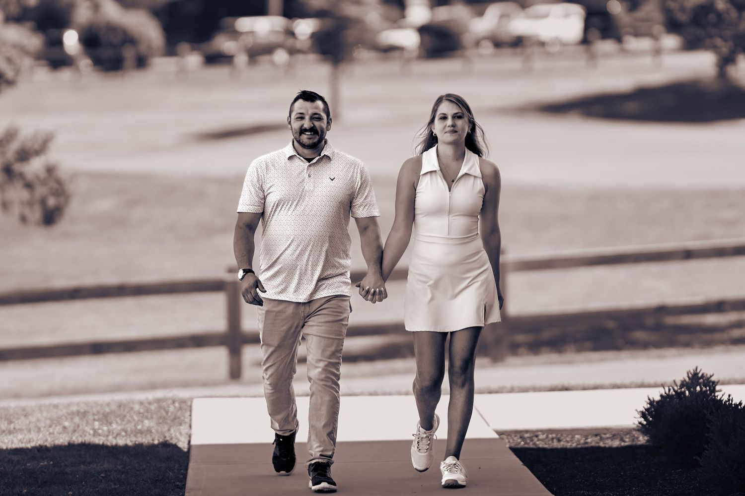 A black and white image showing a couple walking together outdoors.