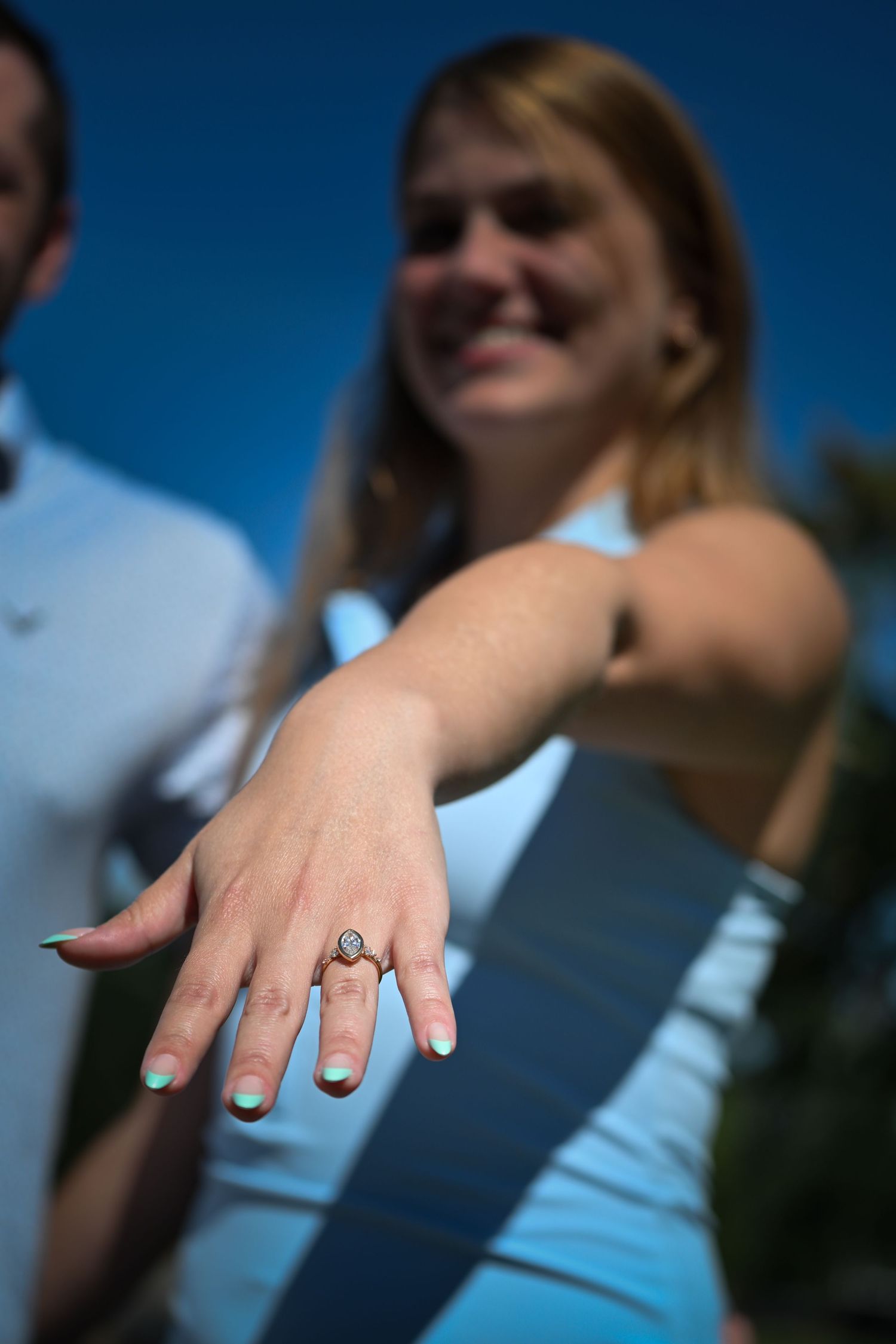 An engagement ring extended on a hand
