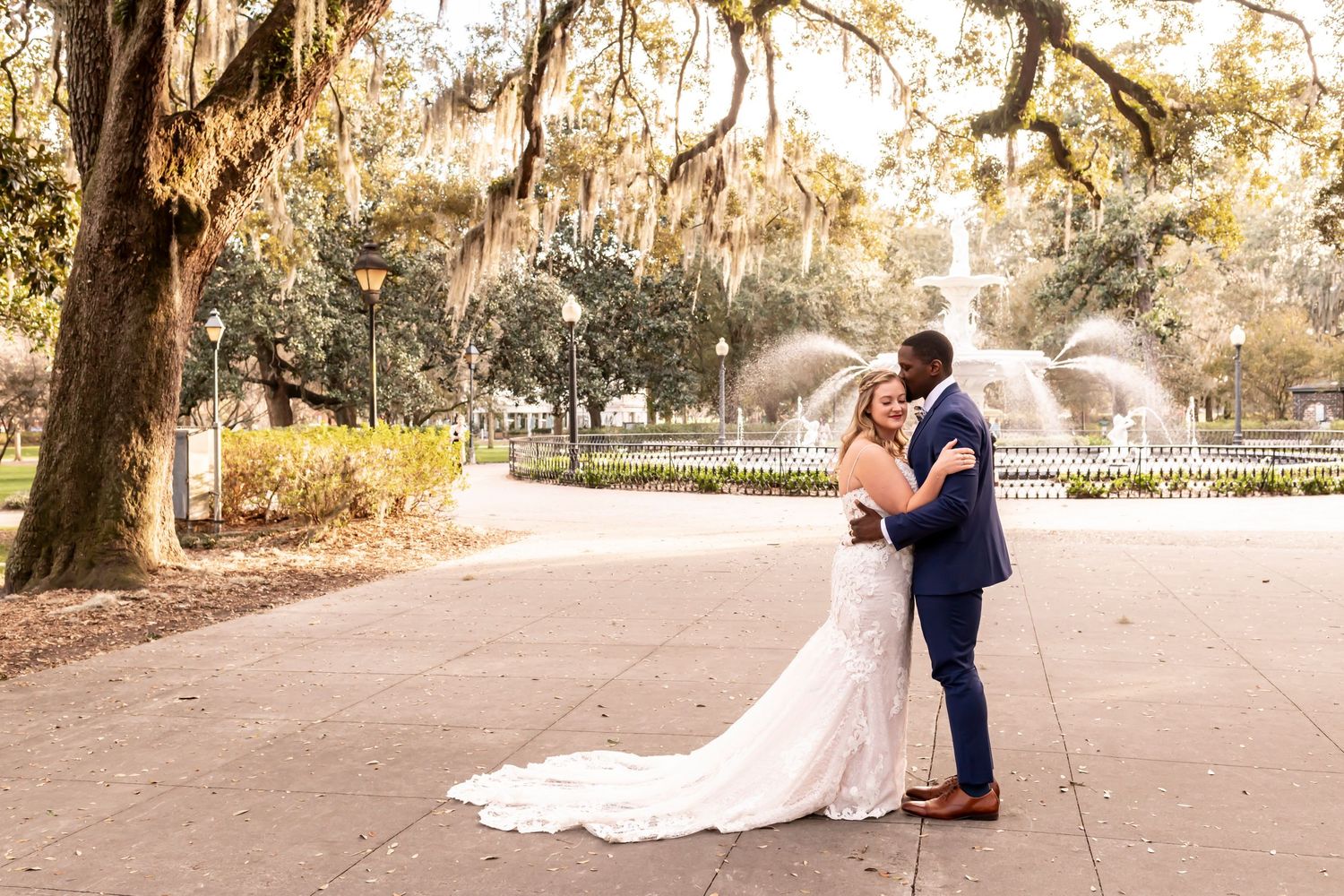 A romantic moment shared between couple during sunset at golden hour under Spanish moss draped trees.