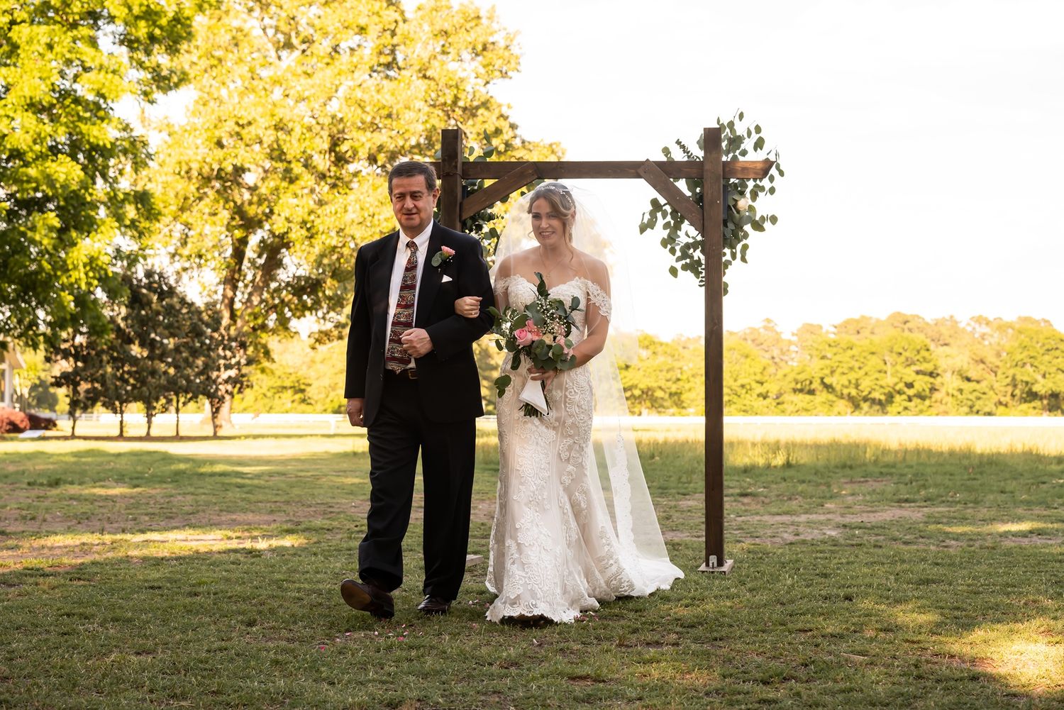 Multiple shots of a wedding ceremony setup outdoors with wooden cross and golden trees in the background.