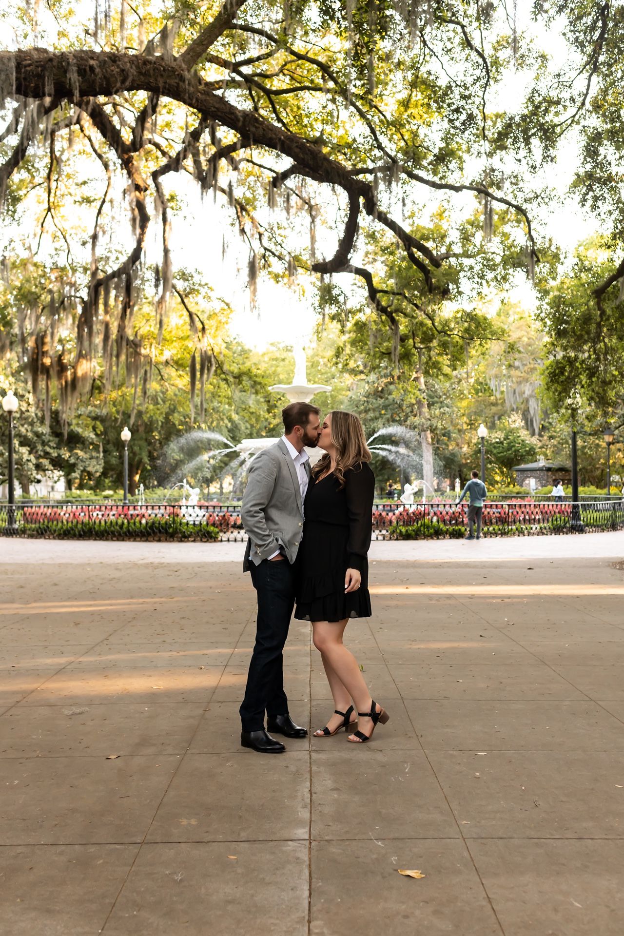 A romantic couple shares intimate moments in a sequence of five photos taken in a park with Spanish moss-draped trees.