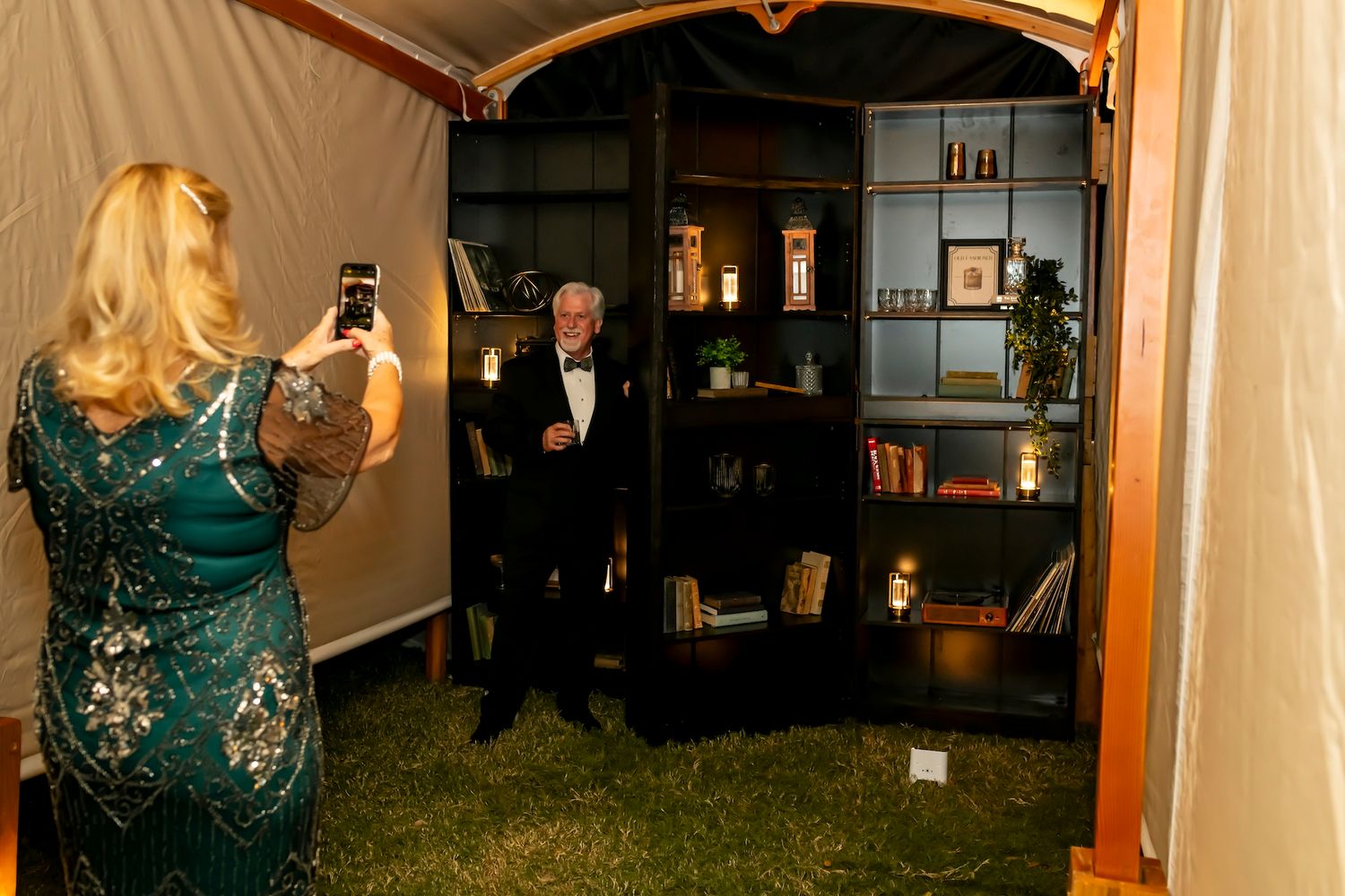 People celebrating in an elegant party setting with a decorated Christmas tree visible in the background.