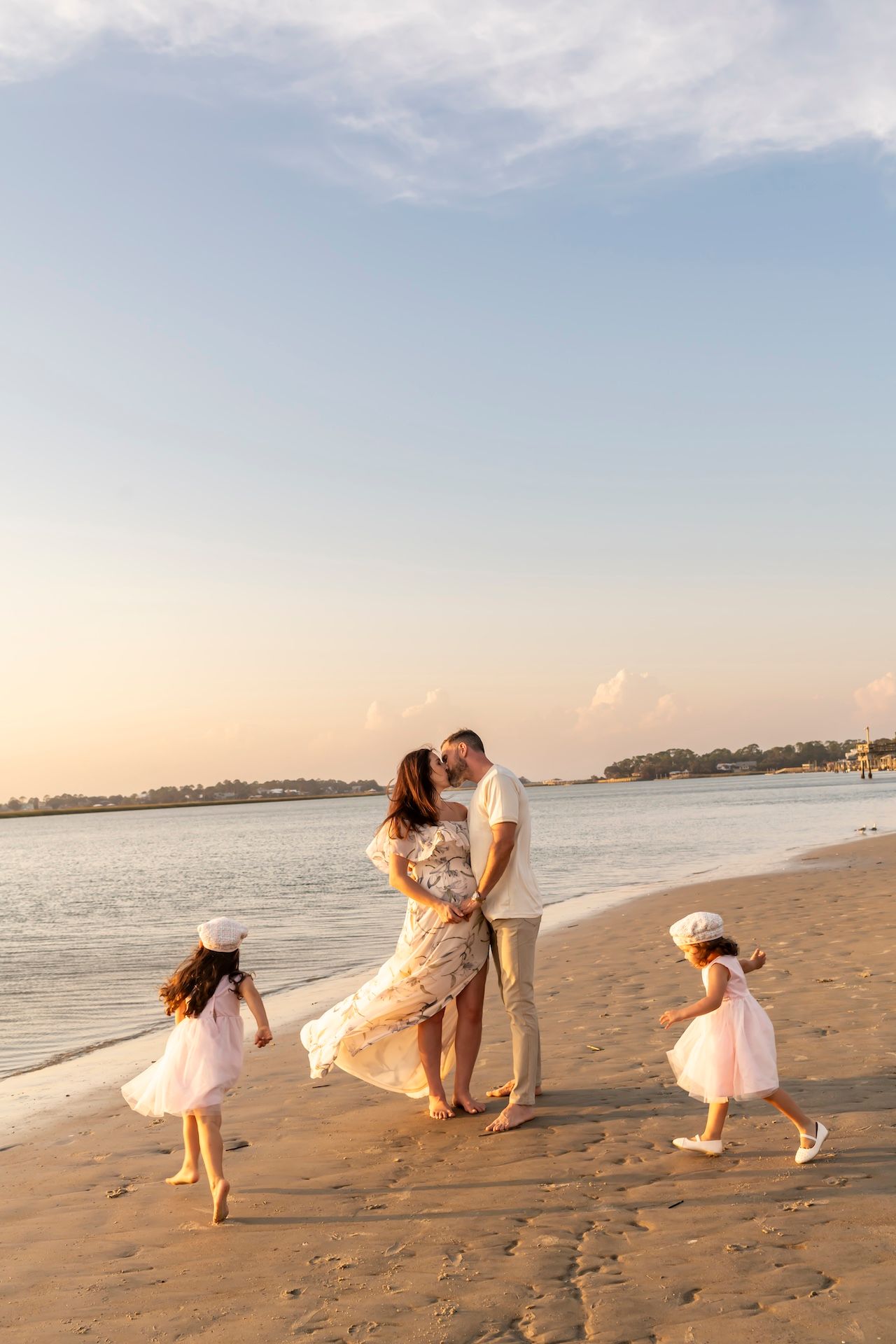 A playful series of beach photos showing dips and lifts with white dresses against a sunset shoreline.