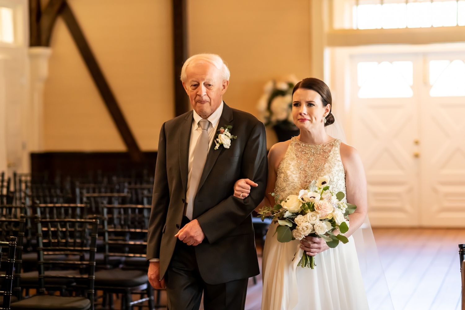 Wedding party assembled in a rustic church venue with wooden beams and natural lighting.