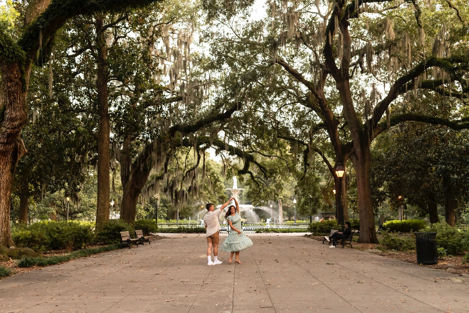 A tranquil pathway lined with Spanish moss-draped oak trees in a lush Southern garden park.