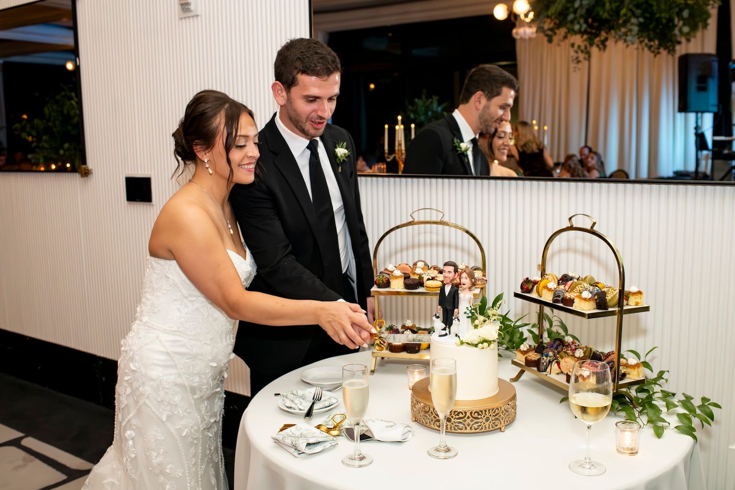 Wedding reception table settings with elegant floral centerpieces, candles and formal place settings at a banquet venue.