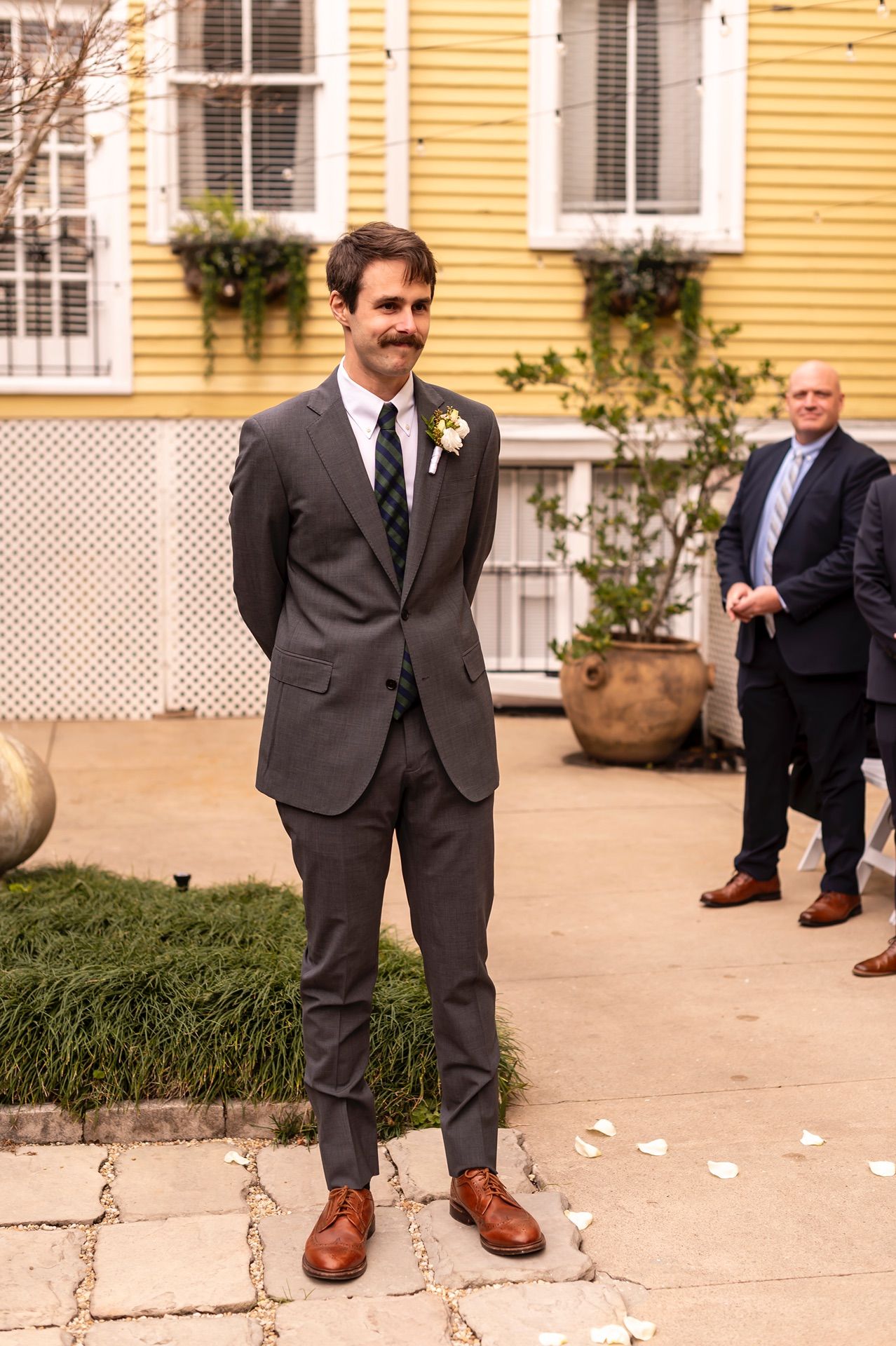 Sequence of groom's feet kicking leaves on sidewalk in fall wedding moment with brown leather shoes.