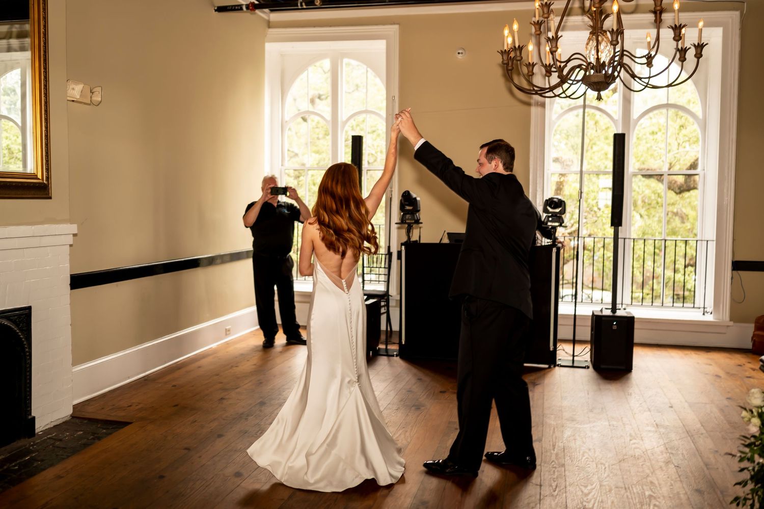 A celebratory moment during a wedding ceremony in an elegant room with hardwood floors and beautiful natural lighting.