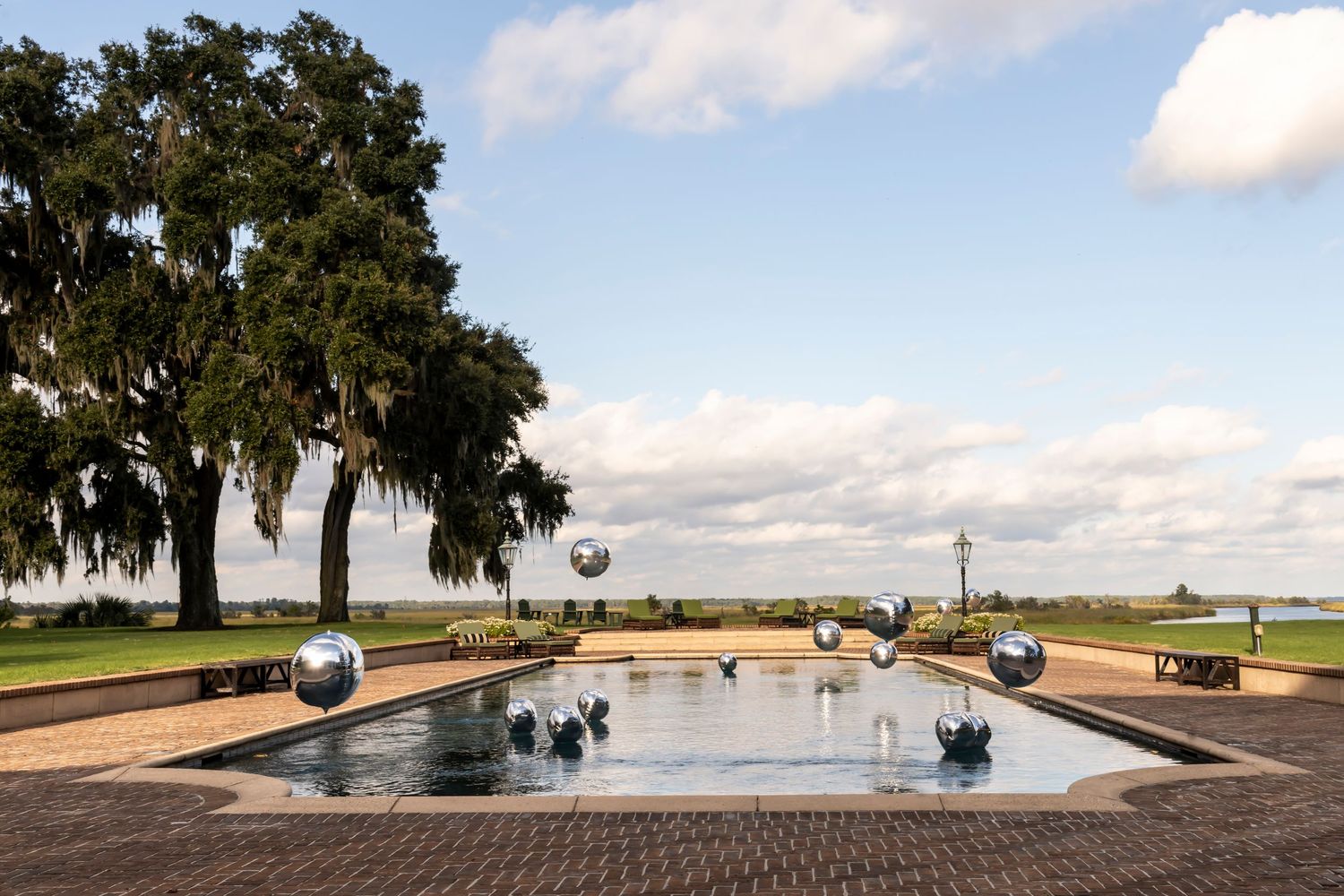 A serene reflecting pool with sphere balloons decorated for an event.