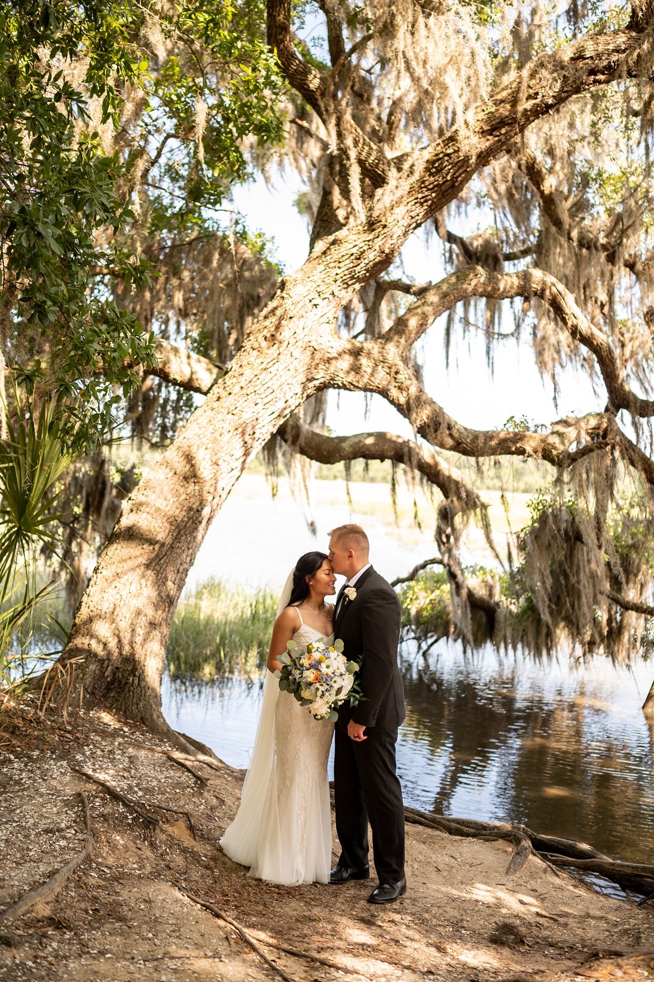 A romantic scene beneath Spanish moss draped oak trees by a tranquil lake with five different poses captured.