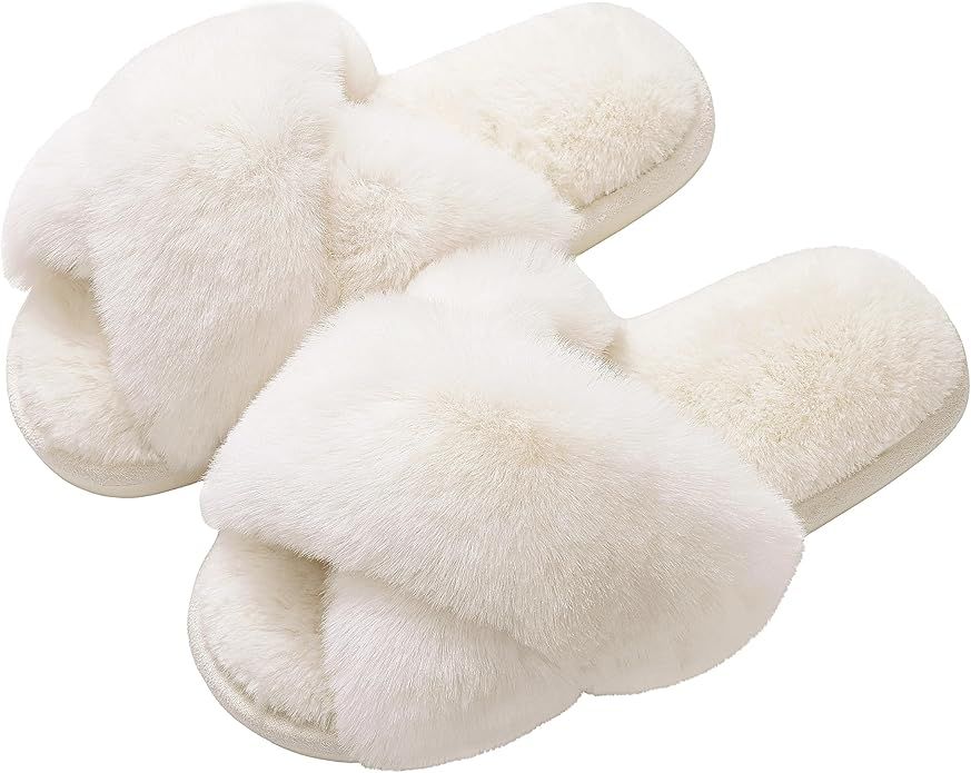 Cozy white fluffy slippers with cross-strap design arranged in a row against white background.